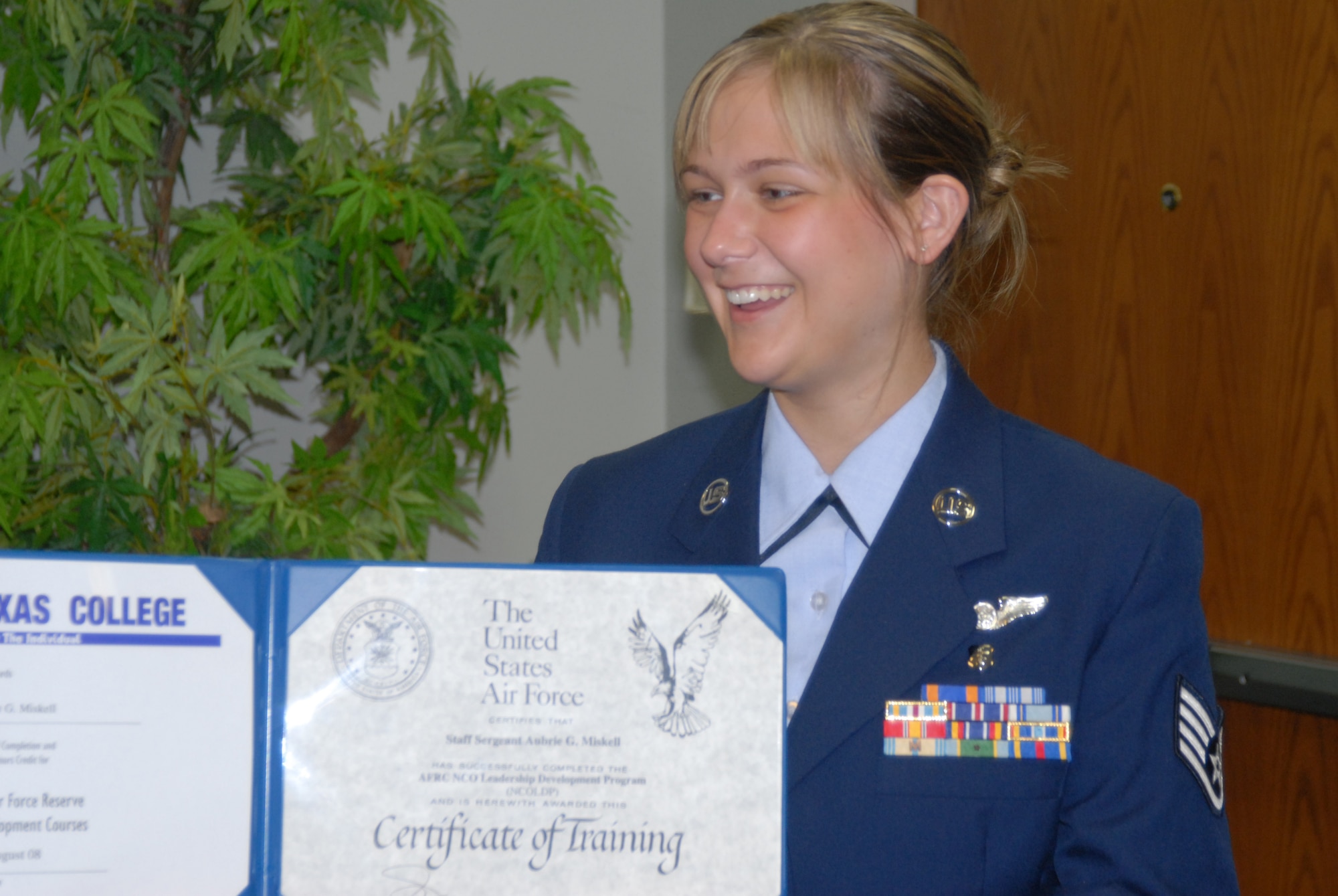 Education certificate goes to Staff Sgt. Aubrie Miskell, as another smart 932nd Airlift Wing member graduates! Tech. Sgt. Marlon Crawford (far left), from the 932nd Airlift Wing's education office, congratulates the new NCO Leadership Develop course graduate recently.. (U.S. Air Force photo/Maj. Stan Paregien) 