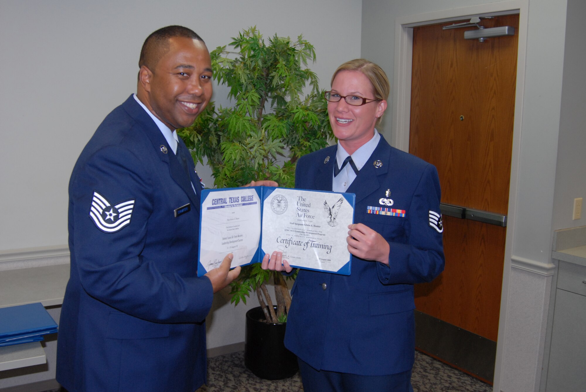 Education certificate goes to Staff Sgt. Jen McGuire, as another serious student and 932nd Airlift Wing member graduates! Tech. Sgt. Marlon Crawford (left), from the 932nd Airlift Wing's education office, congratulates the new NCO Leadership Develop course graduate recently.. (U.S. Air Force photo/Maj. Stan Paregien) 