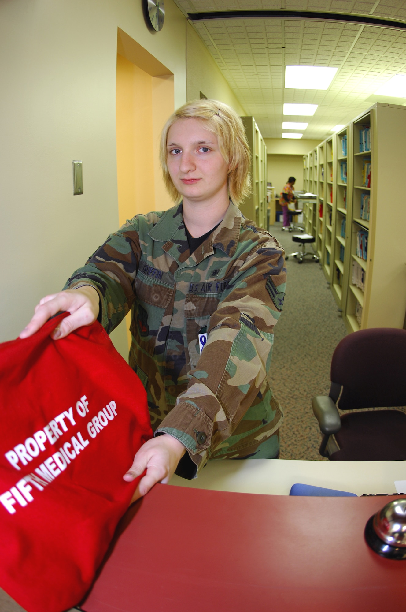 MINOT AIR FORCE BASE, N.D. -- Airman 1st Class Heather Griffin, 5th Medical Support Squadron outpatient clerk, gives a patient their records in a security bag here recently. Outpatient clerk is one of the functions performed by health-service managers. Health-service managers maintain everything from patient records to medically preparing Airmen for upcoming deployments. (U.S. Air Force photo by Airman 1st Class Benjamin Stratton)