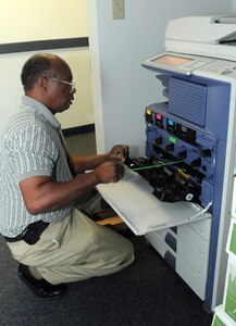 Bobby Kirkpatrick services one of the nearly 300 printer/copiers scattered throughout buildings on Randolph Air Force Base. Kirkpatrick and one other co-worker keep the flow of daily business manageable while also servicing machines on other bases around the San Antonio military community. (U.S. Air Force photo by Rich McFadden)