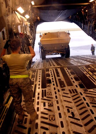 Senior Airman Ashley Kelly guides an M1117 ASV into the back of a C-17 on the Charleston AFB flightline Oct. 24. The Armored Security Vehicle is a four-wheel-drive vehicle that provides ballistic protection to warfighters who are using them against various threats. Airman Kelly is with the 437th Aerial Port Squadron. (U.S. Air Force photo/Airman 1st Class Timothy Taylor)
