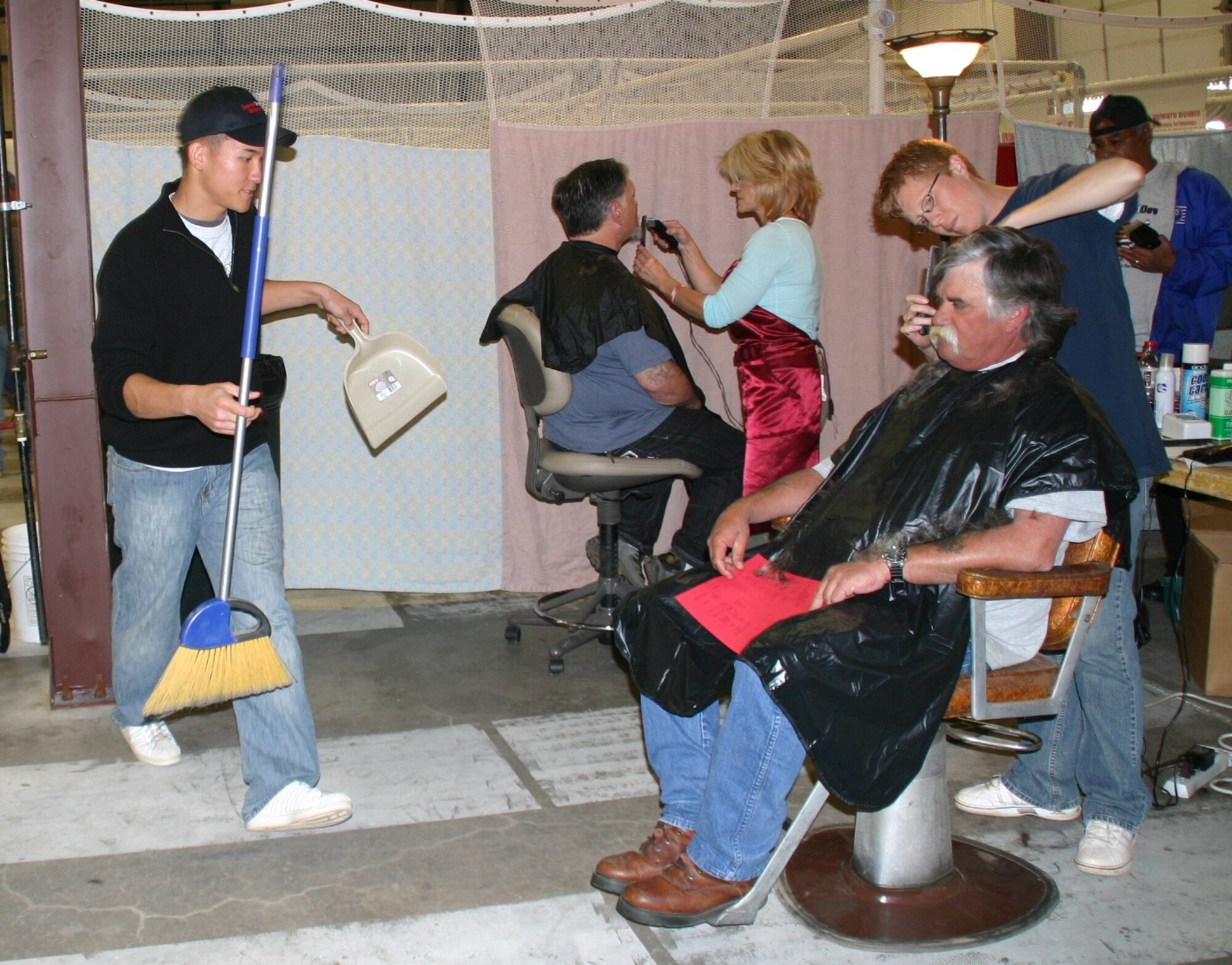Airman Cory Zylstra, 33rd Combat Communications Squadron, helps sweep after veterans receive a free haircut at the Sooner Stand Down. Photo courtesy of 1Lt Kinder Blacke.