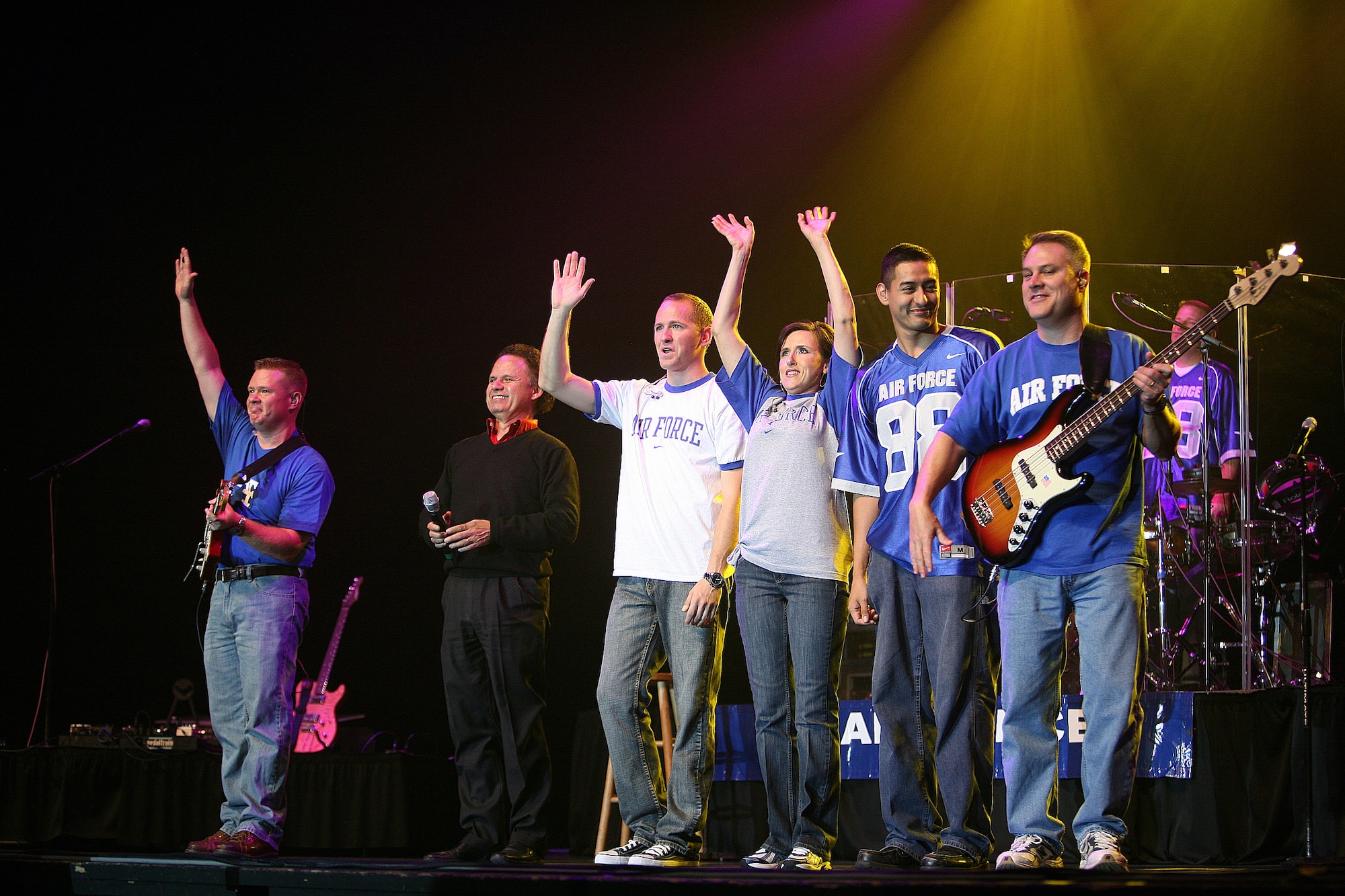 Members of Top Flight wave goodbye to 2,500 middle school children after a 45-minute performance Oct. 22 at the Lila Cockrell Theater in San Antonio. The popular music ensemble of the Band of the West from nearby Lackland Air Force Base performed four shows in support of Red Ribbon Week, a national observance to raise awareness in youth to make the right decisions about substance abuse and inform them on the dangers of drugs. Standing on stage are Tech. Sgt. Steve Wilson, guitar; local radio personality Sonny Melendrez; Airman 1st Class Clayton Lee, vocals; Tech. Sgt. Donna Silver, vocals; Airman 1st Class Dennis Lambert, keyboards; Tech. Sgt. Doug Bennett, bass guitar; and Master Sgt. Tony DeLuzio, drums. (U.S. Air Force photo/Robbin Cresswell)
