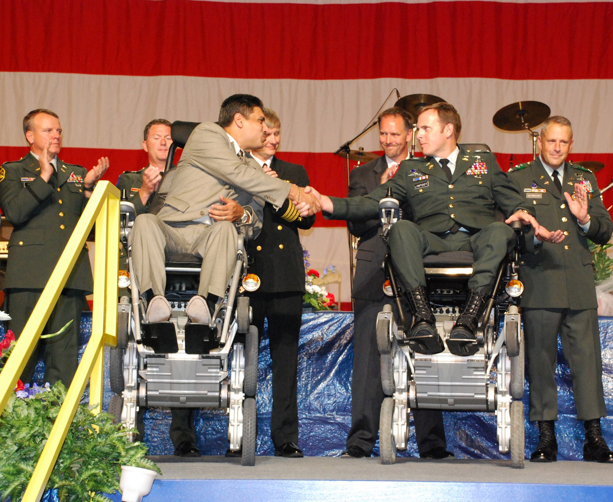 Army Sgt. Elias Reyes (left center) shakes hands with Chief Warrant Officer 4 Gary Linfoot after receiving new iBOT chairs at this year's Skyball VI at Alliance Airport's American Airlines maintainance hangar in Fort Worth, Texas. Through donations from the 501(c)3 nonprofit corporation Huey 091 Foundation's Patriot Fund and through the generous donation from Mr. John Dean, the iBOT Mobility System's all-in-one combination of functions gave these wounded veterans the ability to do what would have once been considered impossible achievements. Each chair cost around $25,000. Skyball is an annual event that its sole purpose is to raise funds to benefit the families of area service men and women. American Airlines and American Eagle partnered with the Fort Worth Airpower Foundation on Sky Ball VI to pursue one more way to honor the heroism of brave men, women and their families. Last year's event raised more than $600,000 for the Navy, Air Force, Marine Corps and National Guard Relief Fund, as well as other needs for families at the Naval Air Station Joint Reserve Base in Fort Worth. (U.S. Air Force Photo/Tech. Sgt. Julie Briden-Garcia)