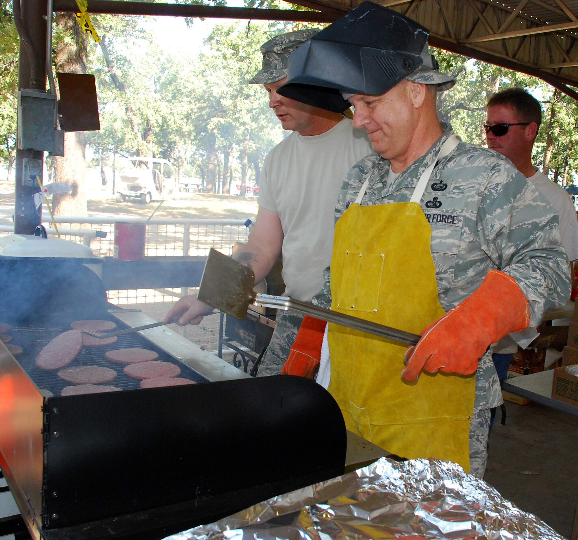 Col. Jolyon Walker, 301st Mission Support Group commander, takes to flipping burgers in the spirit of Family Day at the base marina. Thousands of food portions were passed off to hungry patrons. A representative from the 301st Services Flight commented there were so many people being served that had to go buy more food. Those still in line didn?t seem to mind much; soon mobile food servers began handed out burgers to those waiting. (U.S. Air Force Photo/Tech. Sgt. Julie Briden-Garcia)