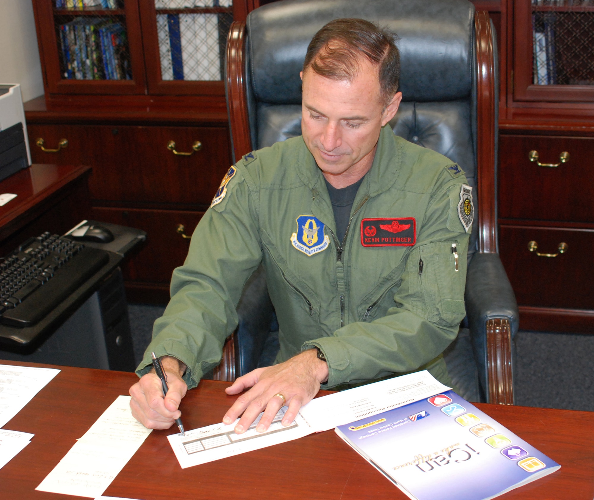 Col. Kevin Pottinger, 301st Fighter Wing commander, signs his Combined Federal Campaign contribution form for this years CFC drive. See your unit?s key worker to get your form and listing of charities to chose from. CFC?s mission is to promote and support philanthropy through a program that is employee focused, cost-efficient, and effective in providing all federal employees the opportunity to improve the quality of life for all.  (U.S Air Force Photo/Maj. Karl Lewis)