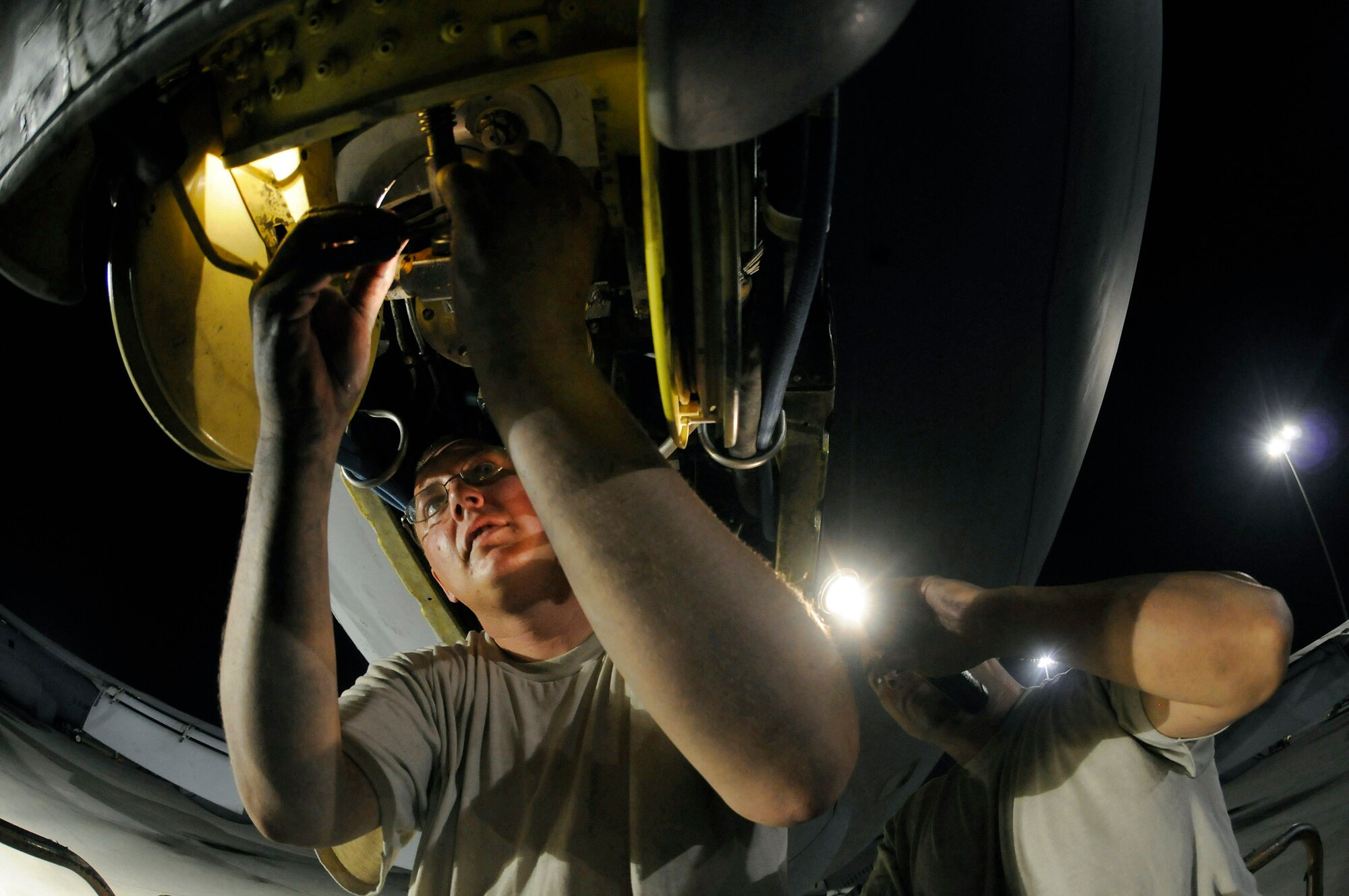 Tech. Sgt. Matthew Massey holds a flashlight while Staff Sgt. Joshua Gill reseals a slide gland of a KC-135 Stratotanker boom Oct. 27 at an air base in Southwest Asia. The KC-135 provides aerial refueling support to Air Force Navy, Marine Corps and Sergeant Massey, a native of Wichita, Kan., and Sergeant Gill, a native of Fonda, N.Y., are both hydraulic technicians assigned to the 379th Expeditionary Aircraft Maintenance Squadron. They are deployed from McConnell Air Force Base, Kan., in support of operations Iraqi Freedom and Enduring Freedom and Joint Task Force-Horn of Africa. (U.S. Air Force photo/Staff Sgt. Darnell T. Cannady) 

