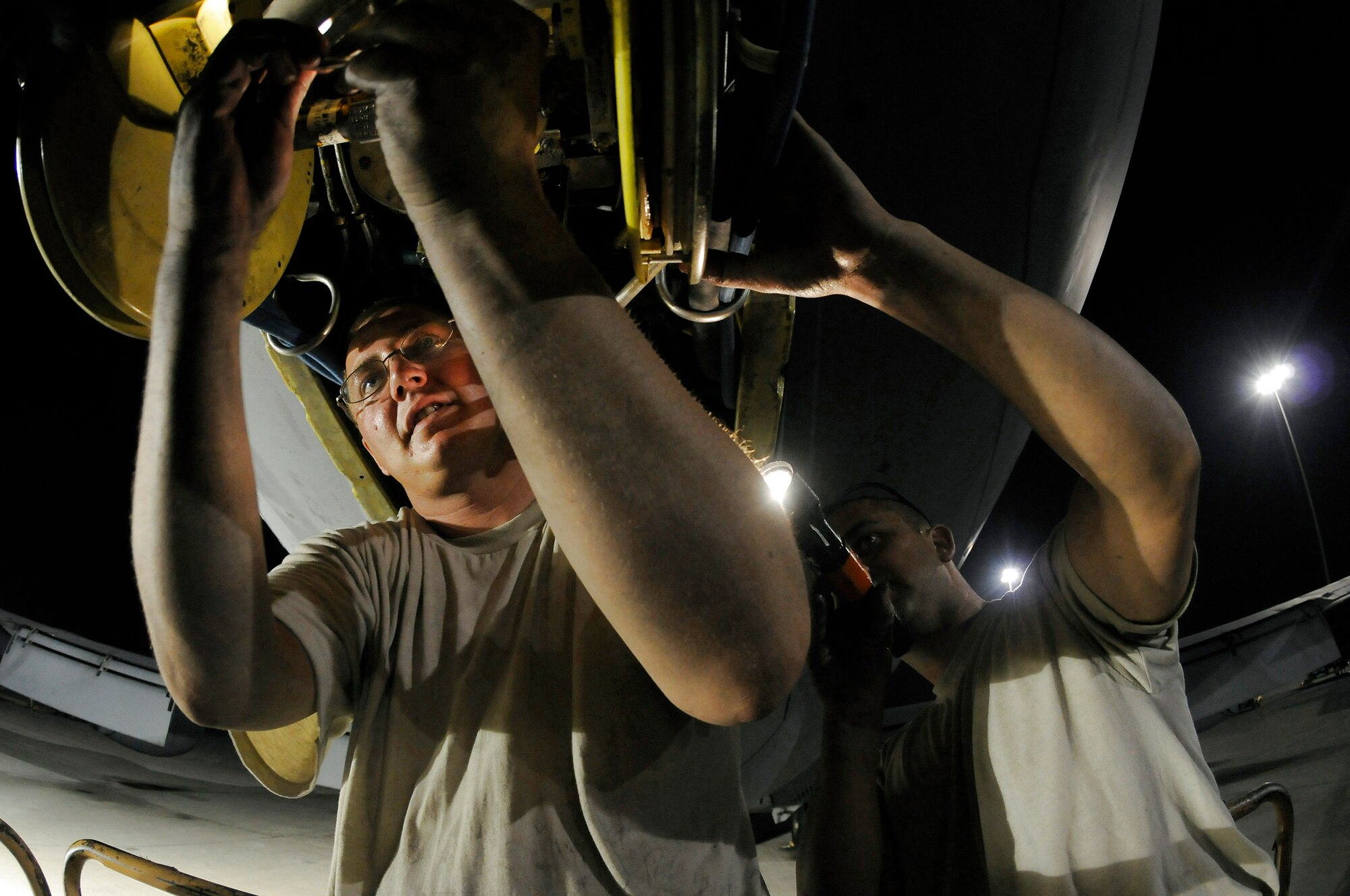 Tech. Sgt. Matthew Massey holds a flashlight while Staff Sgt. Joshua Gill reseals a slide gland of a KC-135 Stratotanker boom Oct. 27 at an air base in Southwest Asia. The KC-135 provides aerial refueling support to Air Force Navy, Marine Corps and allied nation aircraft operating in the Central Command area of responsibility. Sergeant Massey, a native of Wichita, Kan., and Sergeant Gill, a native of Fonda, N.Y., are both hydraulic technicians assigned to the 379th Expeditionary Aircraft Maintenance Squadron. They are deployed from McConnell Air Force Base, Kan., in support of perations Iraqi Freedom and Enduring Freedom and Joint Task Force-Horn of Africa. (U.S. Air Force photo/Staff Sgt. Darnell T. Cannady) 
