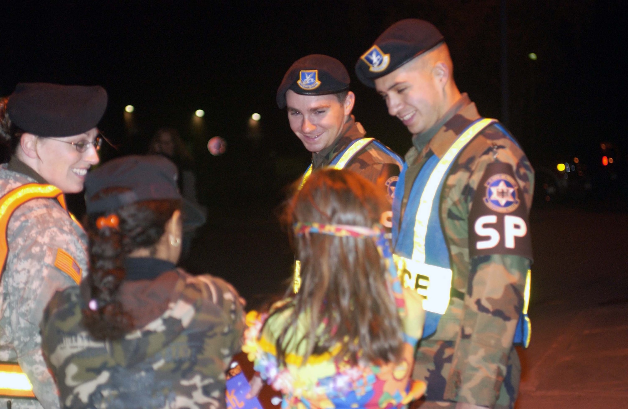 Senior Airman Dylan Gregory (center), from the 569th U.S. Forces Police Squadron, ensures two trick-or-treaters are okay on Halloween last year in the housing area on Landstuhl Regional Medical Center. On the right is his co-worker, Airman 1st Class Sinhue Castro, and to the left is Maj. Jeneen Johnson, who at the time was the U.S. Army Garrison Kaiserslautern provost marshal. Photo by Christine June, USAG Kaiserslautern. 

            