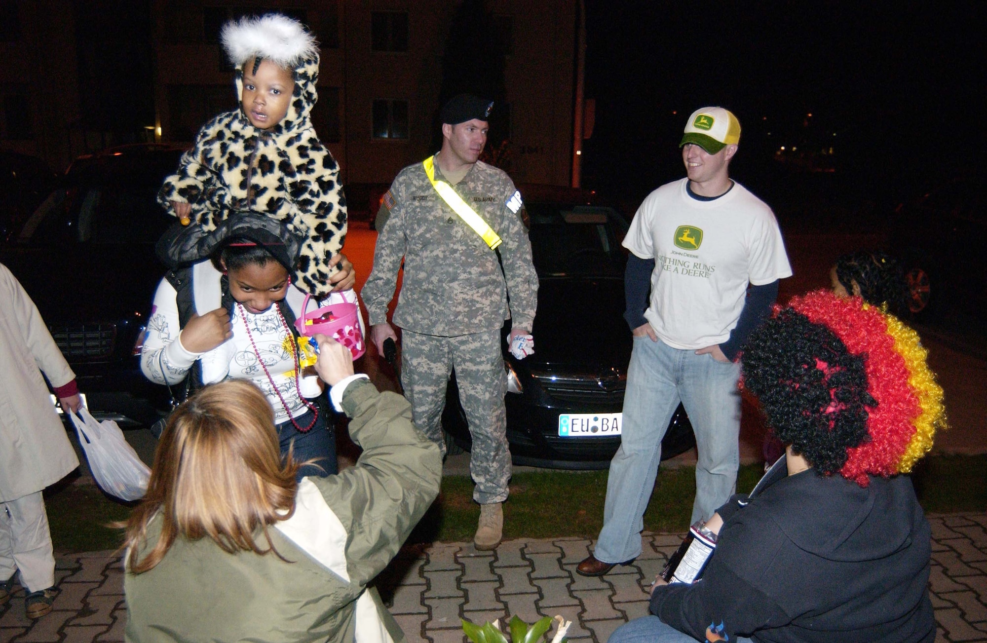 Army Staff Sgt. Patrick Moody, from the U.S. Army Garrison Kaiserslautern Provost Marshal's Office, watches out for trick-or-treaters of all ages on Halloween last year in the housing area on Landstuhl Regional Medical Center. Photo by Christine June, USAG Kaiserslautern. 
      