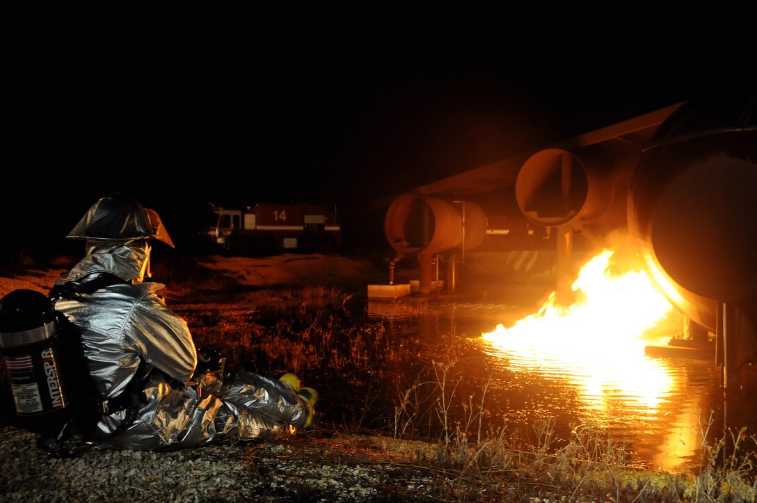 ANDERSEN AIR FORCE BASE, Guam - An Andersen firefighter waits while the trainer is prepared for the live fire training scenario here Oct. 27. Live fire training allows firefighters the opportunity to challenge themselves through realistic scenarios designed to test all levels of experience from the newest Airman in the squadron to seasoned veterans. (U.S. Air Force photo by Airman 1st Class Courtney Witt)