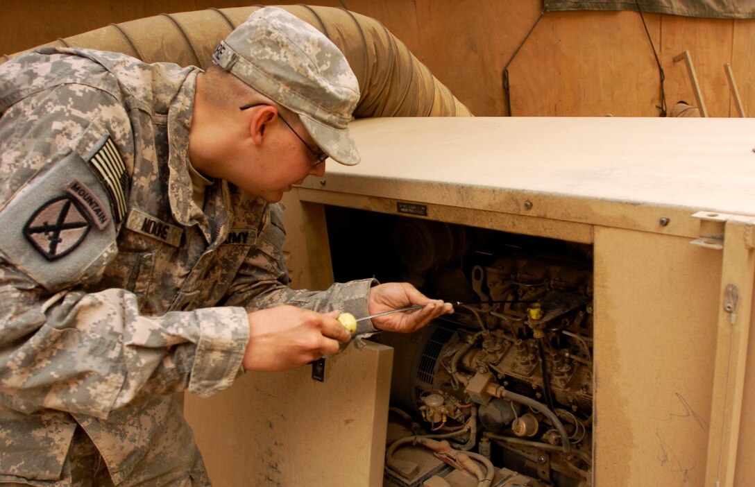 Army Spc. Brent Moore checks the oil level while conducting daily maintenance on the main power supply for the Communication and Electronics shop on Camp Victory, Iraq, Oct. 23, 2008. U.S. Army photo by Staff Sgt. Amber Emery