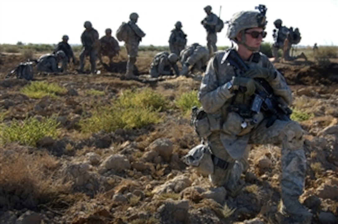 U.S. Army Spc. Edward Brodzinski provides security while other soldiers unearth a weapons cache in the rural region of Zoba, Iraq, on Oct. 4, 2008.  Brodzinski and the soldiers are assigned to 1st Battalion, 27th Infantry Regiment, 2nd Stryker Brigade Combat Team, 25th Infantry Division.  The site is known to hold numerous hidden weapons caches.  