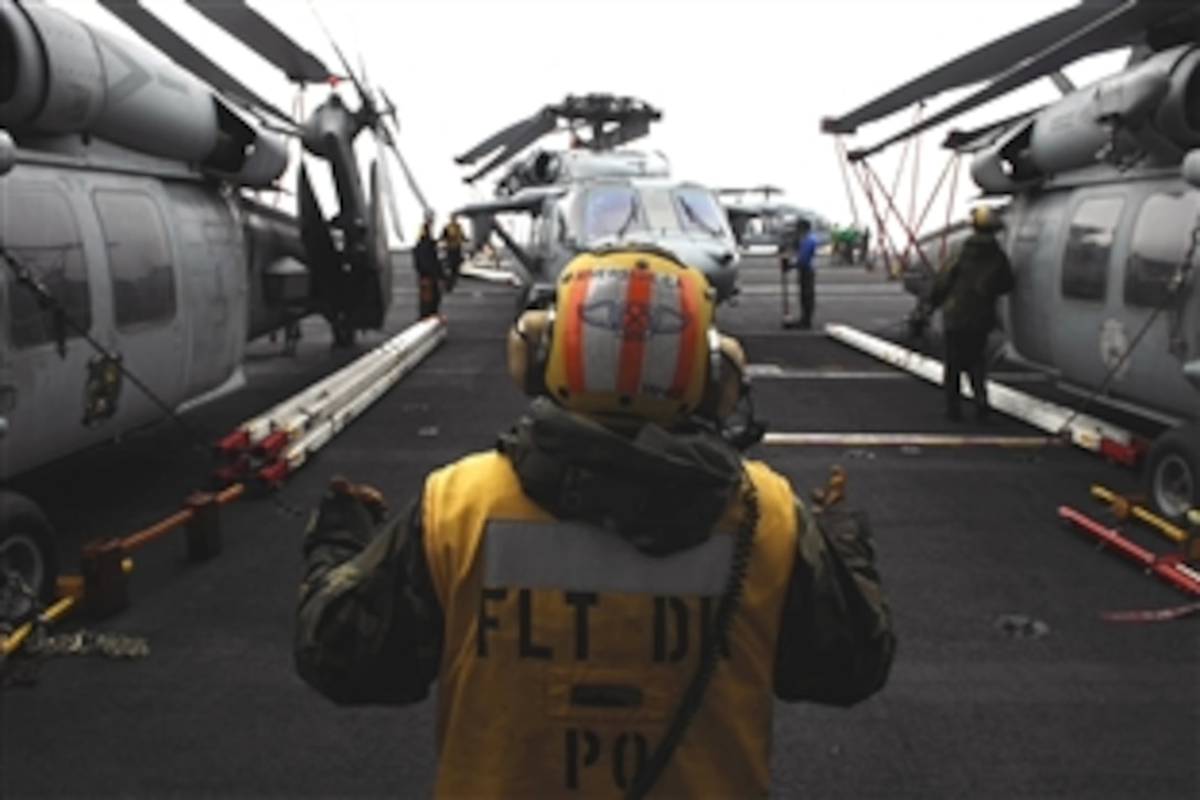 U.S. Navy Petty Officer 1st Class Dennis Yanez directs an MH-60S Sea Hawk from the
into the helo-hole on the flight deck of the USS John C. Stennis, which is under way in the Pacific Ocean, Oct. 25, 2008. 
