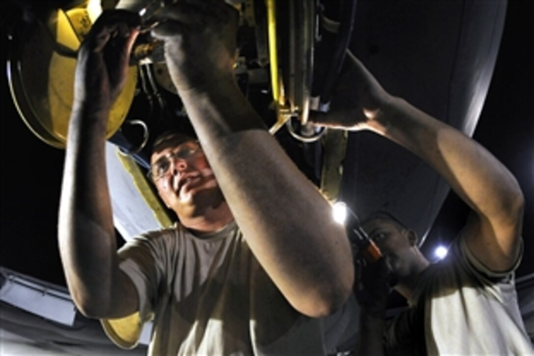 U.S. Air Force Tech. Sgt. Matthew Massey, right, holds a flashlight while Staff Sgt. Joshua Gill reseals a slide gland on a KC-135 Stratotanker boom at an air base in Southwest Asia, Oct. 27, 2008. Massey and Gill are hydraulic technicians assigned to the 379th Expeditionary Aircraft Maintenance Squadron.