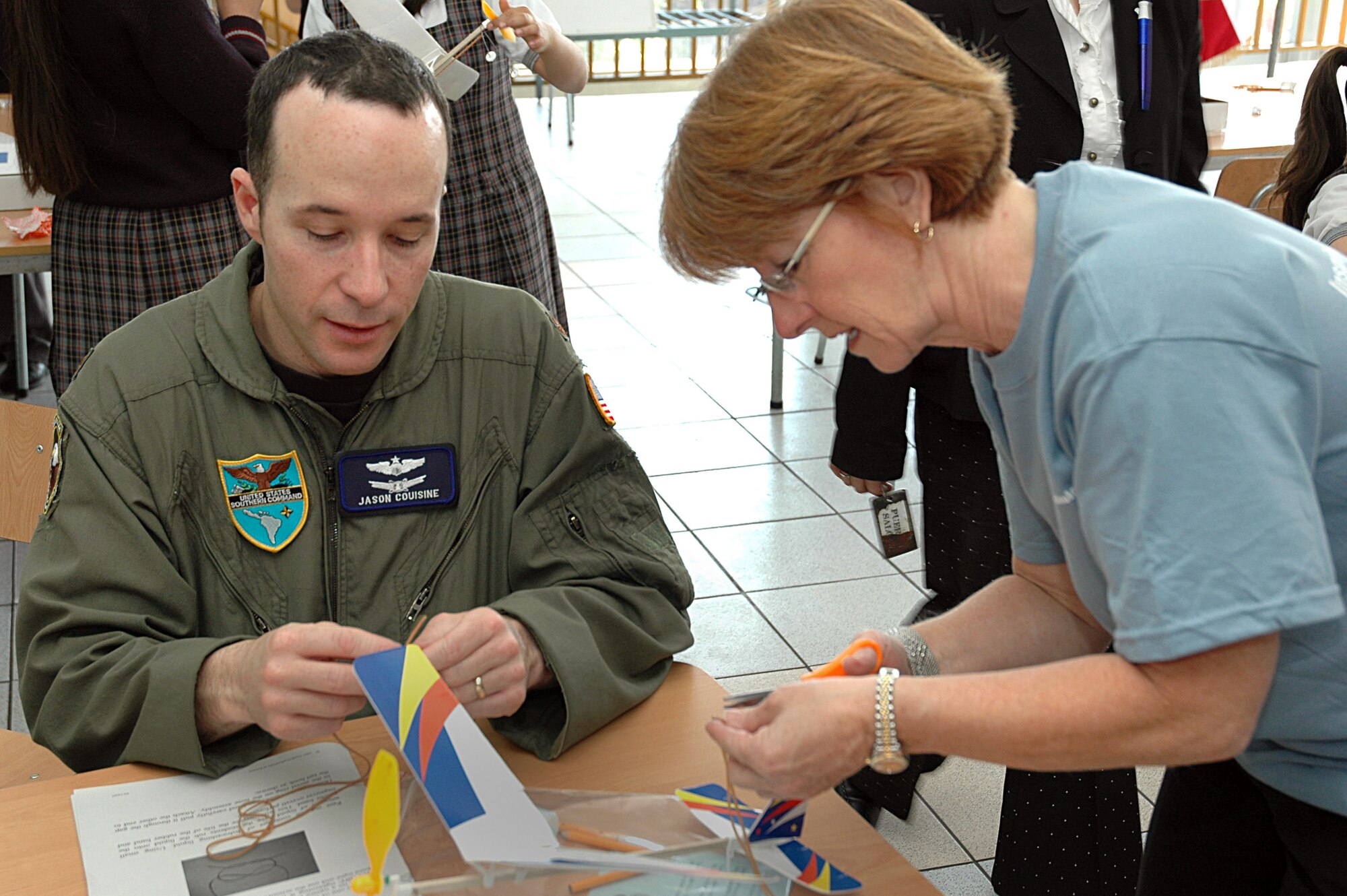 Maj. Jason Couisine (left) the Air Force section chief at the U.S. Military Group in Chile, and Arlene Dickson, corporate relations manager at Agilent Technologies, acted as schoolteachers during a guest science class at the Complejo Educacional Esperanza School in Santiago, Chile on Oct. 27. The community outreach event was part of Air Forces Southern's Operation Southern Partner, an all-new program aimed at providing intensive, periodic subject matter exchanges with partner nations in the U.S. Southern Command area of focus.  Volunteers from Agilent and the U.S. Military Group worked alongside Air Forces Southern, the Chilean air force and members of the U.S. Embassy to teach local school children the practical applications of scientific principles by building and flying model airplanes. (U.S. Embassy photo/Jose Nuños)