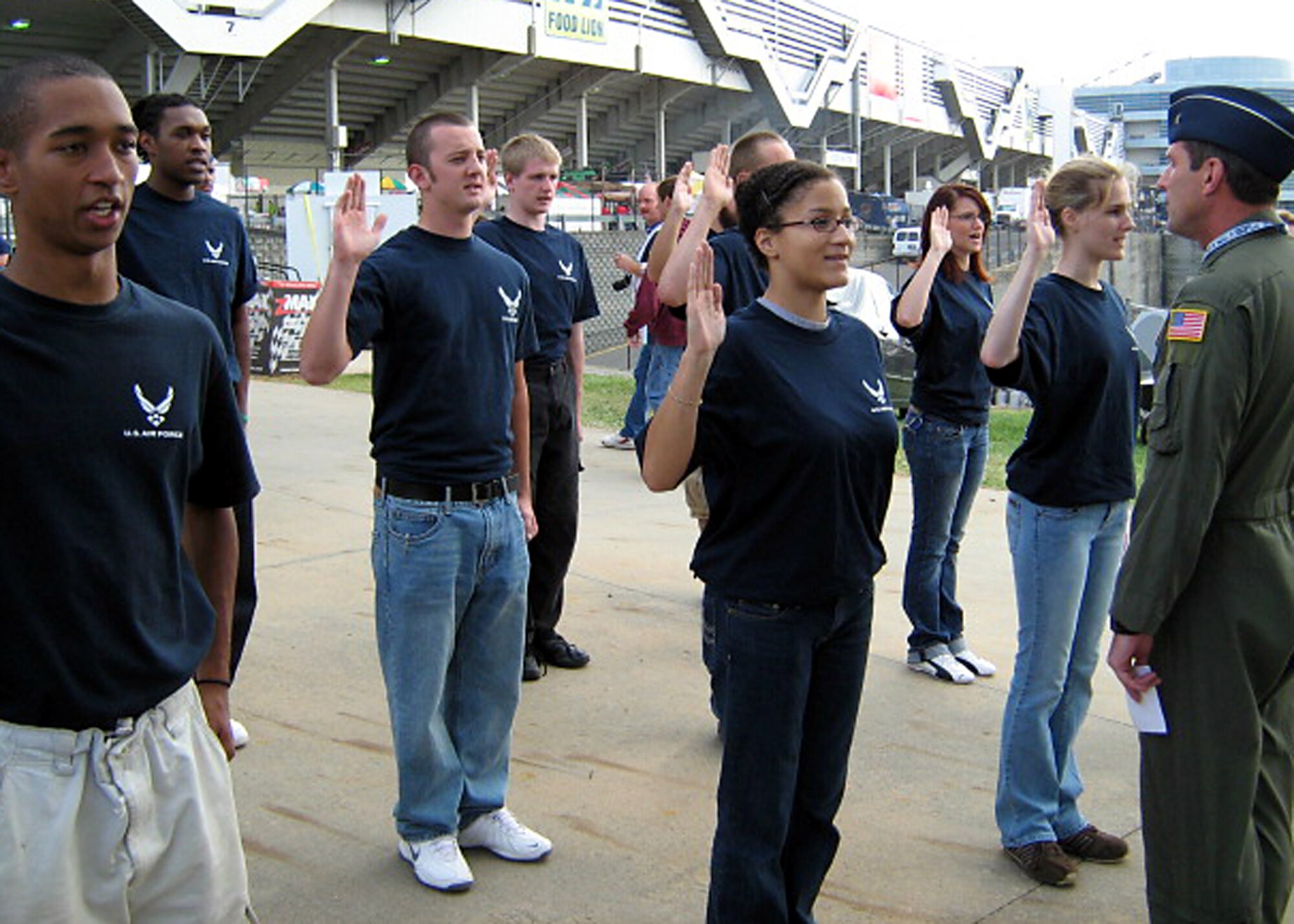 Brig. Gen. Robert C. Kane conducts a public swearing-in ceremony for 337th Recruiting Squadron Delayed Entry Program members Oct. 11 during the Bank of America 500 NASCAR race at Lowe’s Motor Speedway in Concord, N.C. The 18th Air Force vice commander from Scott Air Force Base, Ill., personally greeted each of the 16 future Airmen and the families attending the ceremony, and wished the Airmen well in their careers. The ceremony drew the attention of race fans with whom 337th recruiters and DEP members gladly shared Air Force information. Tours of the race pit, close views of the race cars and meeting the drivers proved a morale booster for all the 337th RCS members at the event. (U.S. Air Force photo/Tech. Sgt. Roberto Cruz)