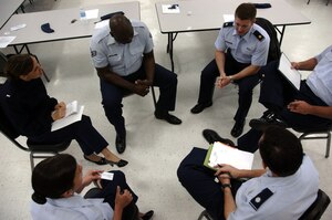 Members of the 437th Airlift Wing staff discuss the meaning of teamwork quotes during a Wingman Day activity on base Oct. 27. Squadrons and units on base participated in various Wingman Day events to bring members together and provide information to create a culture of responsible choices. (U.S. Air Force photo/Airman 1st Class Timothy Taylor)