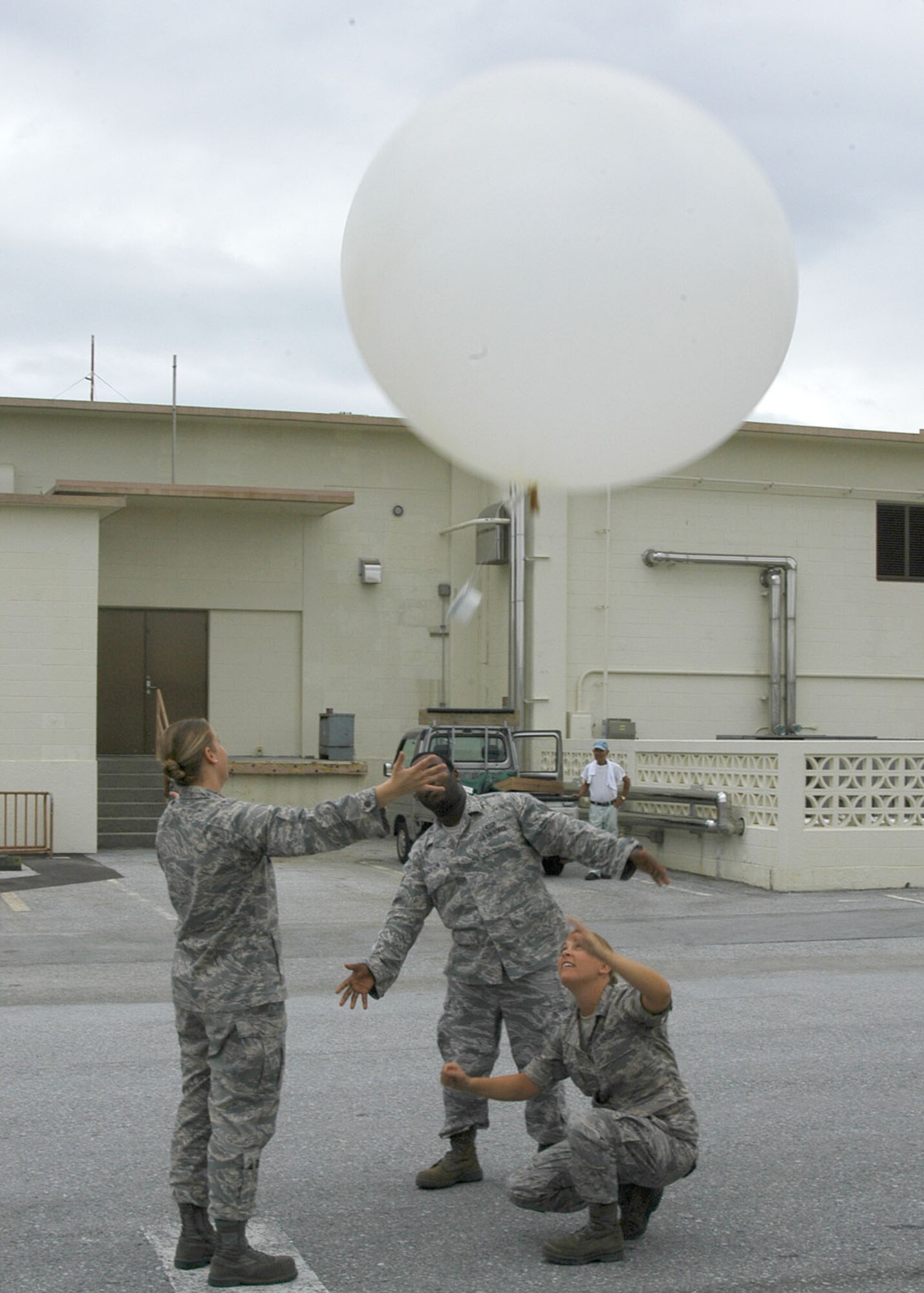 KADENA AIR BASE, Japan -- From left: 1st. Lt. Lindsey Fennewald, Senior Airman Michael Jackson and Staff Sgt. Sara Klobucar, all from the 353rd Operations Support Squadron Weather Flight, release a helium-filled weather balloon here Oct. 27. A radiosonde attached to the weather balloon measures pressure, temperature and relative humidity as it ascends into the atmosphere; and sends the data back to the MW31 sounding system every one to two seconds. The data provides valuable input for computer forecast models, local forecasts and future weather research.  (U.S. Air Force photo by Tech. Sgt. Aaron Cram)                                 