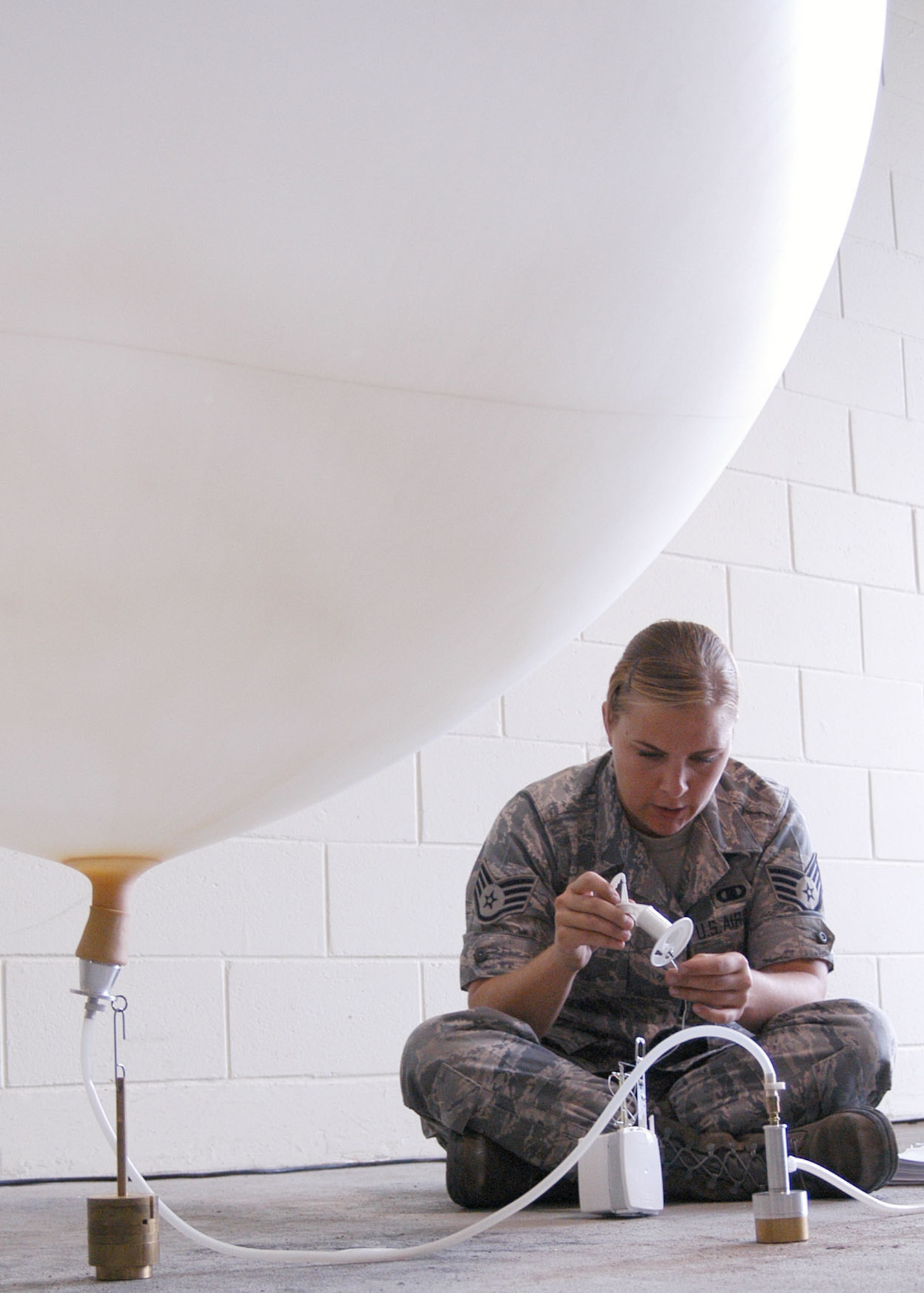 KADENA AIR BASE, Japan -- Staff Sgt. Sara Klobucar, 353rd Operations Support Squadron weather technician, prepares a radiosonde before attaching it to a helium-filled weather balloon here Oct. 27. The radiosonde measures pressure, temperature and relative humidity as it ascends into the atmosphere; and sends the data back to the MW31 sounding system every one to two seconds. The data provides valuable input for computer forecast models, local forecasts and future weather research.  (U.S. Air Force photo by Tech. Sgt. Aaron Cram)                                