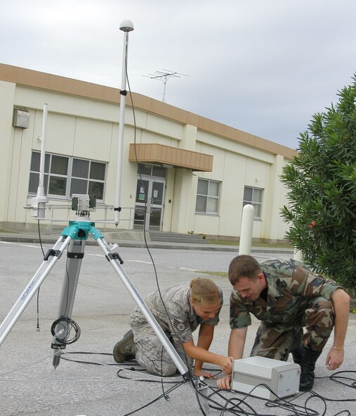 Staff Sgts. Sara Klobucar and David Simpson, 353rd Operations Support Squadron weather technicians, set up a MW31 sounding system before launching a helium-filled weather balloon here Oct. 27. A radiosonde attached to the weather balloon measures pressure, temperature and relative humidity as it ascends into the atmosphere; and sends the data back to the sounding system every one to two seconds. The data provides valuable input for computer forecast models, local forecasts and future weather research. (U.S. Air Force photo by Tech. Sgt. Aaron Cram) 