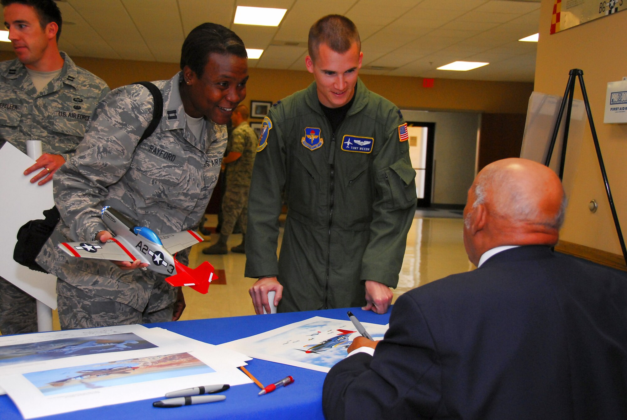 Capt. Roslynn Rayford and Capt. Tony Weedn speak to retired Lt. Col. William Holloman, one of the original Tuskegee Airmen who addressed scores of captains completing their training at Squadron Officer School at Maxwell Air Force Base, Ala. (U.S. Air Force photo/Scott Knuteson) 
