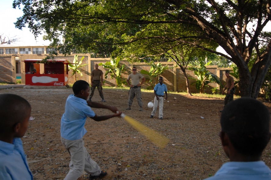 SANTO DOMINGO, Dominican Republic -- Airmen from the 5th Civil Engineer Squadron Prime Base Engineer Emergency Force and Navy Seabees,currently embarked aboard USS Kearsarge (LHD 3), take a break and join Dominican children in a game of baseball at Soccoro Sanchez Primary School. Airmen from the 5th CES and Navy engineers are working together to repair and improve the school in support of the humanitarian/civic assistance mission Continuing Promise (CP) 2008. CP 2008 is a collaborative effort between the United States and partner militaries, non-governmental organizations, and partner-nation support organizations to build strong partnerships that can be called upon in the event of a regional situation requiring cooperative solutions. (U.S. Navy photo by Mass Communication Specialist Seaman Ernest Scott)