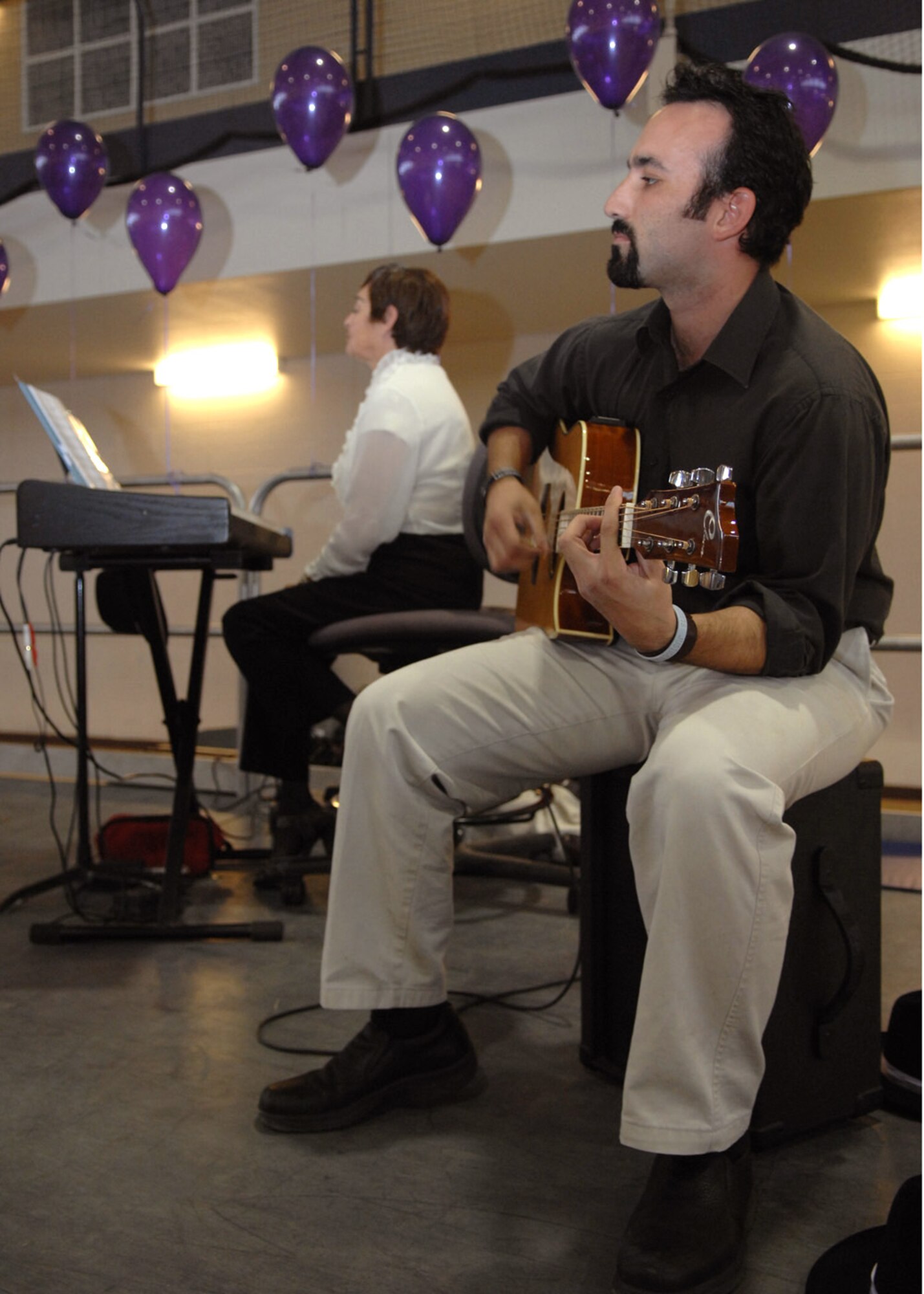 Nathan Stell-Smith strums the guitar at the Domestic Violence Musical, October 24. As part of his character, actor Stell-Smith romantically influences the troubled actors that were involved in an abusive relationship while they performed on stage at the Fitness and Sports Center at Holloman Air Force Base, N.M. (U.S. Air Force photo/Airman 1st Class Veronica Salgado)