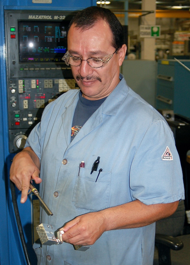 Louis Macias, a machinist with the 530th Commodities Maintenance Squadron at Hill Air Force Base, Utah, air blasts a newly manufactured T-38 aileron lever to remove excess coolant following the third machine operation. (U.S. Air Force photo/Bill Orndorff) 
