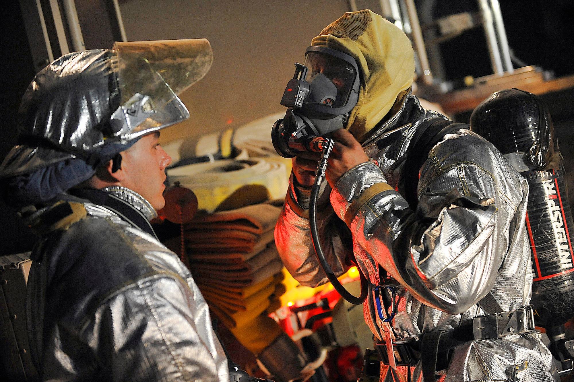 Airman 1st Class Nicholas Smallwood helps Staff Sgt. Brian Plemons don protective equipment Oct. 22 at Joint Base Balad, Iraq. The Joint Base Balad Fire Department conducted the burn as part of a live-fire training scenario to give individual firefighters experience using hose patterns on interior fires. Both Airmen are deployed to the 332nd Expeditionary Civil Engineer Squadron from MacDill Air Force Base, Fla. (U.S. Air Force photo/Airman 1st Class Jason Epley) 