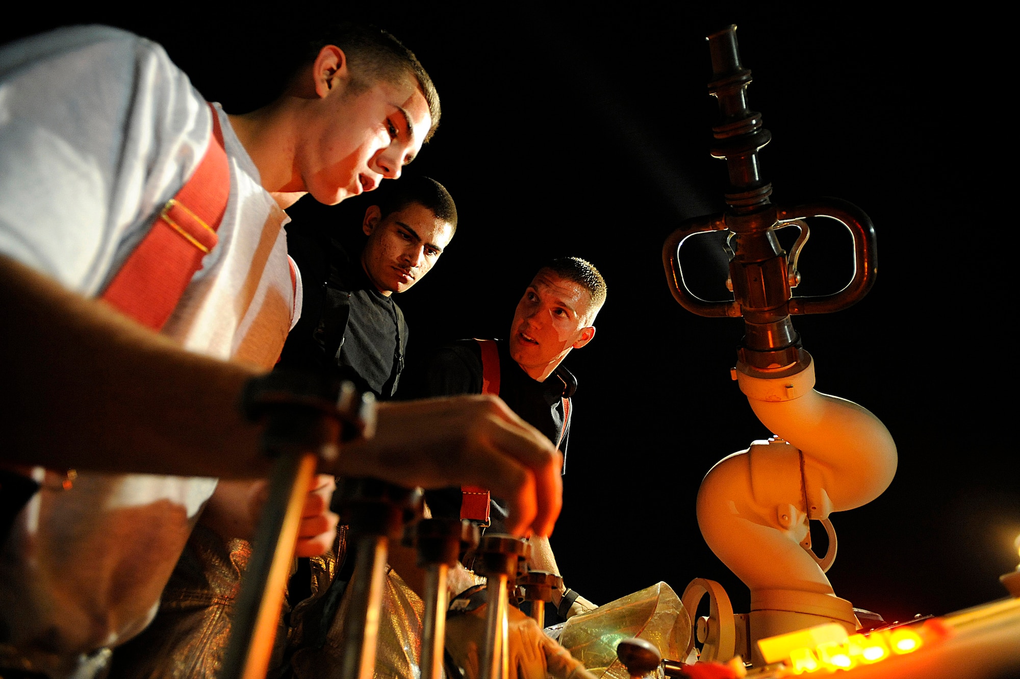 Airman Daniel Mellstead, Airman Anthony Beavers and Senior Airman Roger Halle rehearse hose pattern procedures during a live-fire training scenario Oct. 22 at Joint Base Balad, Iraq. The Joint Base Balad Fire Department conducted a controlled burn as part of the scenario, giving individual firefighters experience at fighting interior fires. All three Airmen are assigned to the 332nd Expeditionary Civil Engineer Squadron. Airman Beavers is deployed from McChord Air Force Base, Wash. Airmen Mellstead and Halle are deployed from Peterson AFB, Colo. (U.S. Air Force photo/Airman 1st Class Jason Epley) 