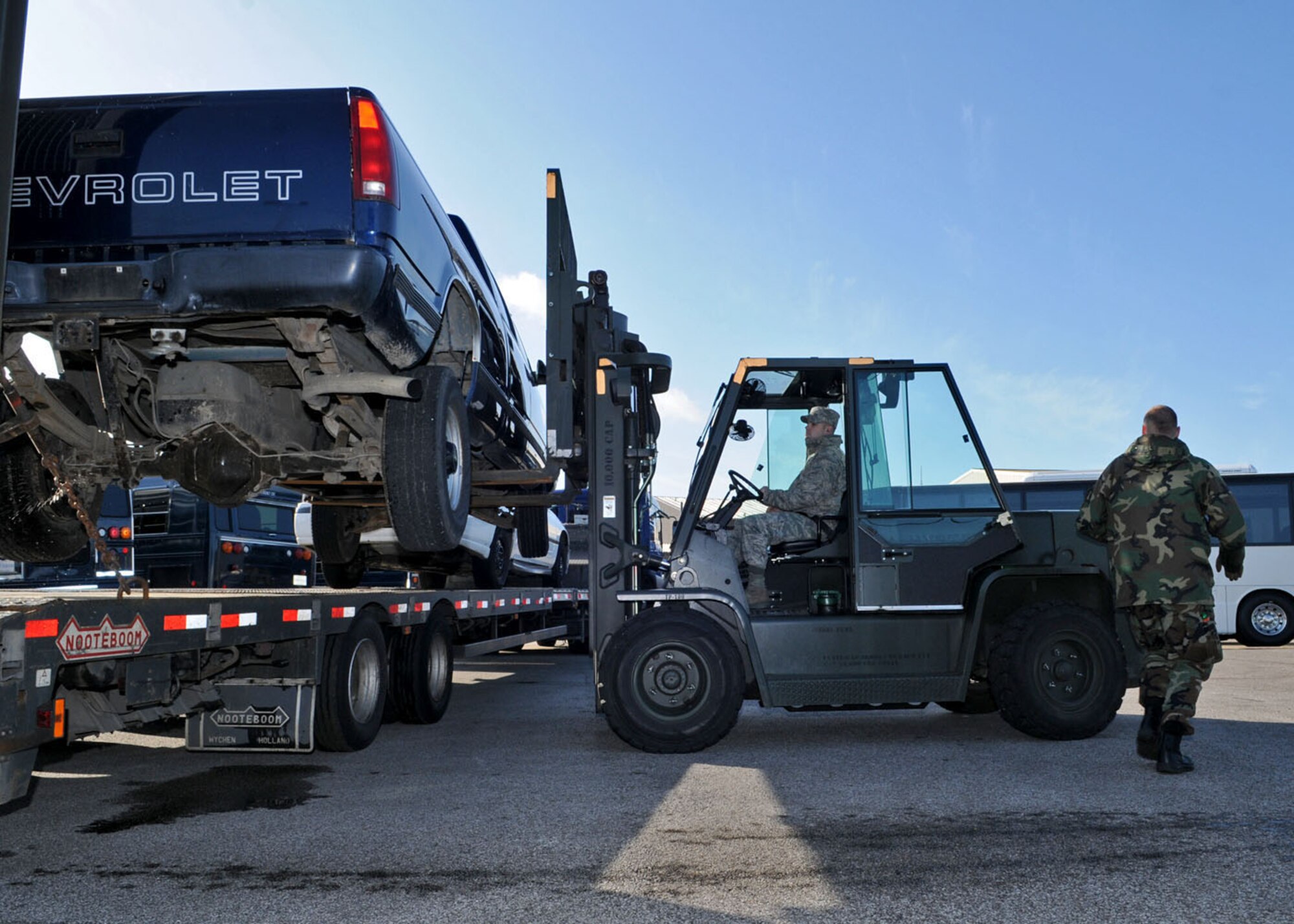 Airman 1st Class Mathew Benoit, right, and Justin Chapman, both from the 100th Logistics Readiness Squadron, maneuver a vehicle onto a flatbed Oct. 27, 2008. The vehicle was being turned into the Defense Reutilization Marketing Office (DRMO) after years of military use. (U.S. Air Force photo by Staff Sgt. Jerry Fleshman)