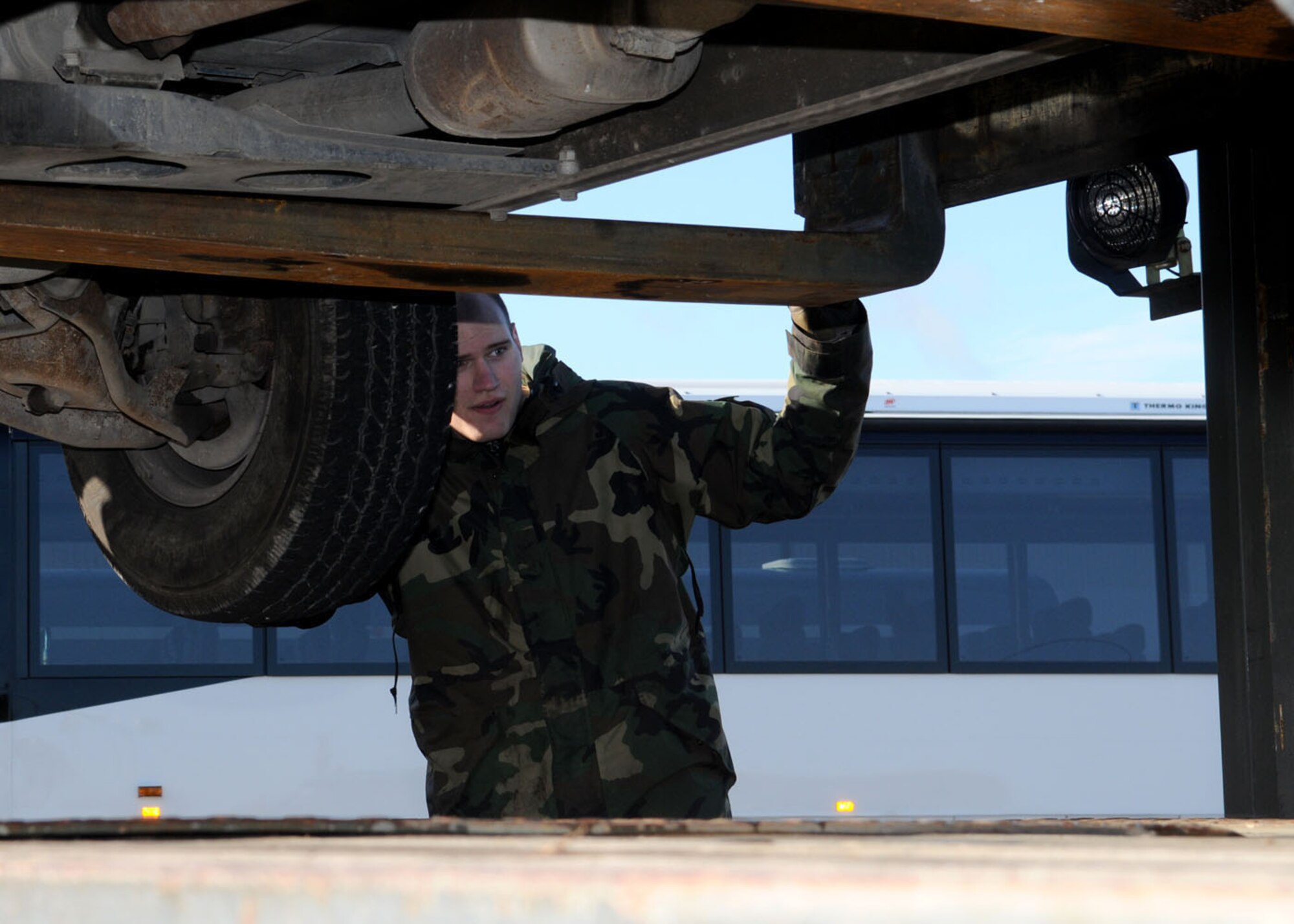 Airman 1st Class Mathew Benoit, a vehicle operator from the 100th Logistics Readiness Squadron, ensures proper clearance prior to lowering a vehicle onto a flatbed Oct. 27, 2008. The vehicle was being turned into the Defense Reutilization Marketing Office (DRMO) after years of military use. (U.S. Air Force photo by Staff Sgt. Jerry Fleshman)