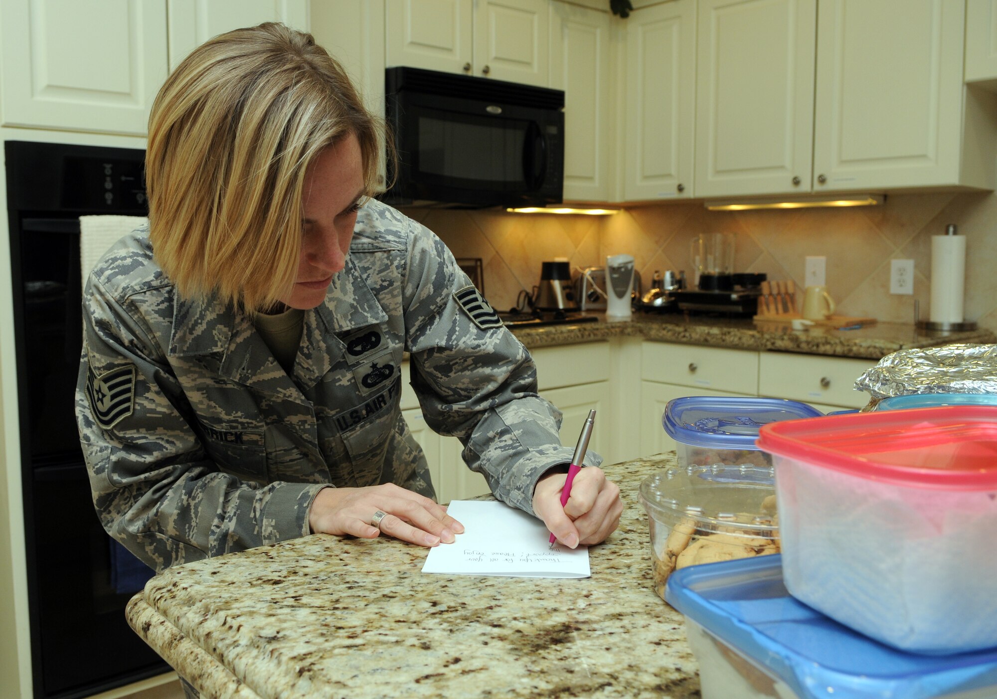 Tech. Sgt. Rachel Herrick, Air Education and Training Command Logistics and Middle Tier Association president, leaves a note for patients staying at the Fisher House on Ft. Sam Houston, Texas, on Oct. 27. Sergeant Herrick and Staff Sgt. Titus Butler (not pictured), Air Force Manpower Agency and MTA member, collected and donated more than 30 dozen cookies baked by MTA members to the Fisher House at Ft. Sam Houston. (U.S. Air Force photo by Rich McFadden)
