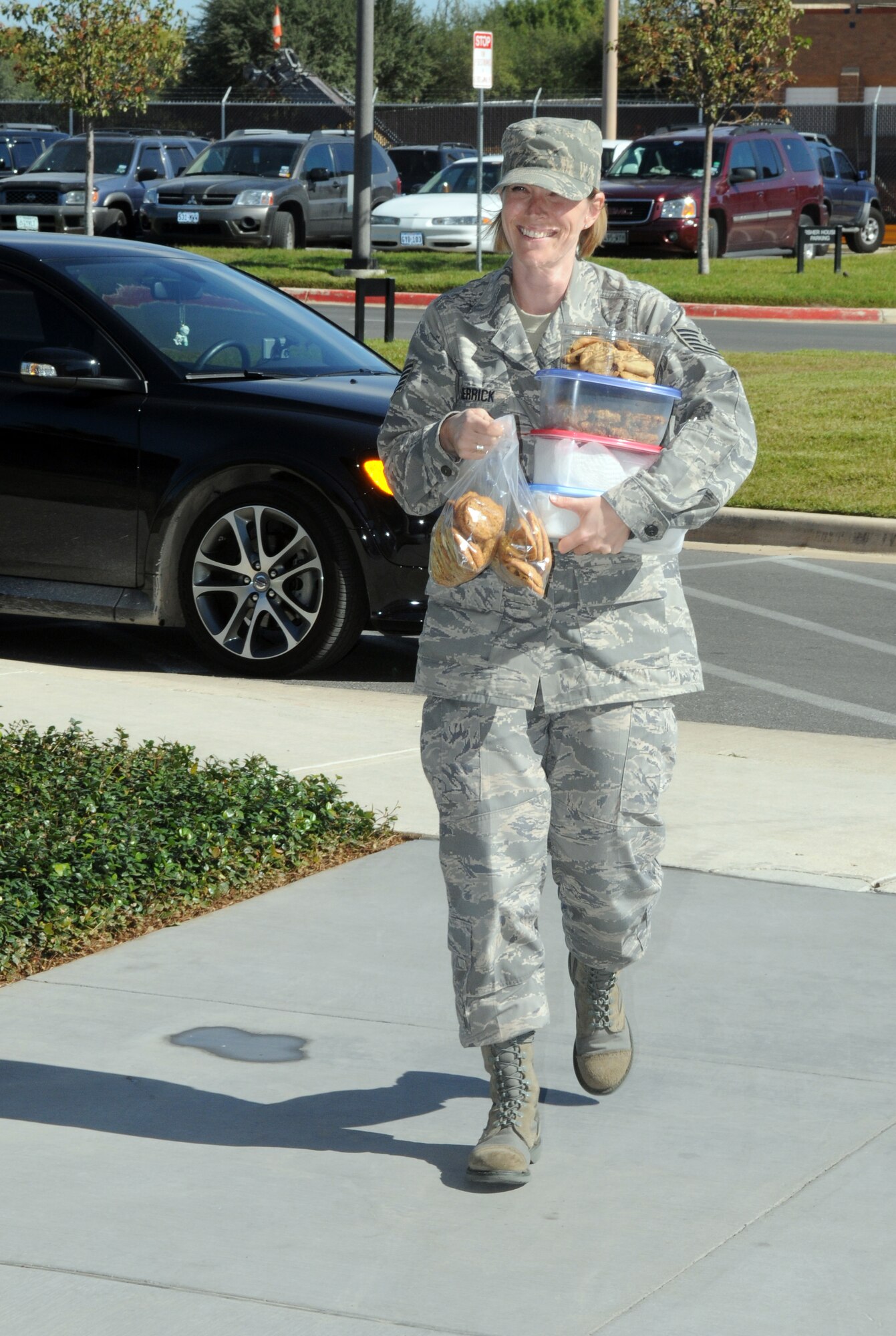 Tech. Sgt. Rachel Herrick, Air Education and Training Command Logistics and Middle Tier Association president, carries cookies into the Fisher House at Ft. Sam Houston, Texas, on Oct. 27. Sergeant Herrick and Staff Sgt. Titus Butler (not pictured), Air Force Manpower Agency and MTA member, collected and donated more than 30 dozen cookies baked by MTA members to patients staying at the Fisher House at Ft. Sam Houston. (U.S. Air Force photo by Rich McFadden)