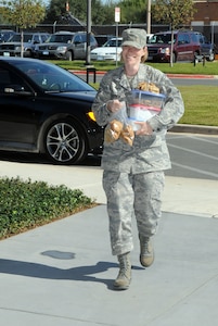 Tech. Sgt. Rachel Herrick, Air Education and Training Command Logistics and Middle Tier Association president, carries cookies into the Fisher House at Ft. Sam Houston, Texas, on Oct. 27. Sergeant Herrick and Staff Sgt. Titus Butler (not pictured), Air Force Manpower Agency and MTA member, collected and donated more than 30 dozen cookies baked by MTA members to patients staying at the Fisher House at Ft. Sam Houston. (U.S. Air Force photo by Rich McFadden)