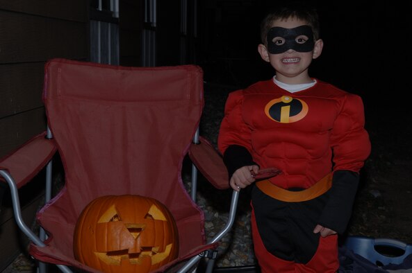 Maddox Cummings, stepson of Senior Airman Kristopher Kingan, 28th Bomb Wing Public Affairs broadcaster, presents his carved pumpkin.  One of the safety measures the wing has in place for children on the night of Halloween is "Pumpkin Patrol," which is conducted by 28th Security Forces Squadron. (U.S. Air Force photo/Senior Airman Kristopher Kingan)