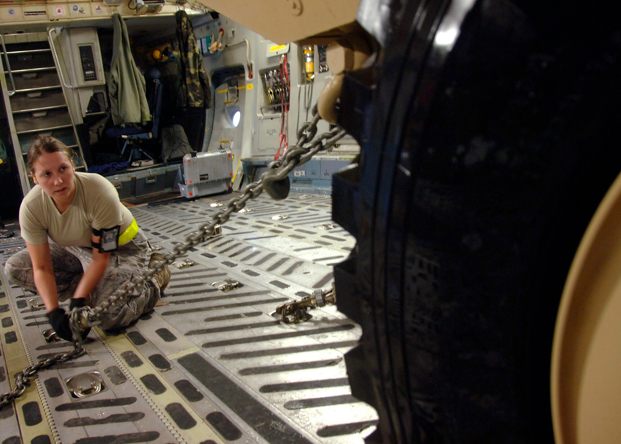 Senior Airman Ashley Kelly tightens a clamp to secure an armored security vehicle to the bed of a C-17 Globemaster III Oct. 24 at Charleston Air Force Base, S.C. The ASV is a four-wheel-drive vehicle that provides ballistic protection to warfighters who are using them against various threats. Airman Kelly is assigned to the 437th Aerial Port Squadron. (U.S. Air Force photo/Airman 1st Class Timothy Taylor) 
