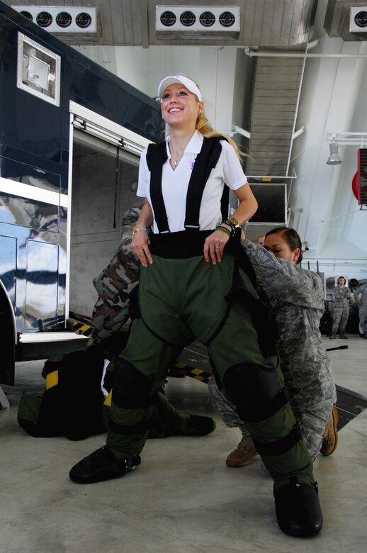 ANDERSEN AIR FORCE BASE, Guam - Staff Sgt. Sherri Streu, 36th Civil Engineer Squadron helps Ms. Anna Kournikova put on the Explosive Ordnances Disposal-9 Bombsuit, while touring here at Hangar 1 Oct. 29.  The  Explosive Ordnances Disposal-9 Bombsuit is used by EOD to prevent injuries and even death during the disposal of explosive ordnances. (U.S. Air Force photo by Airman 1st Class Nichelle Griffiths)