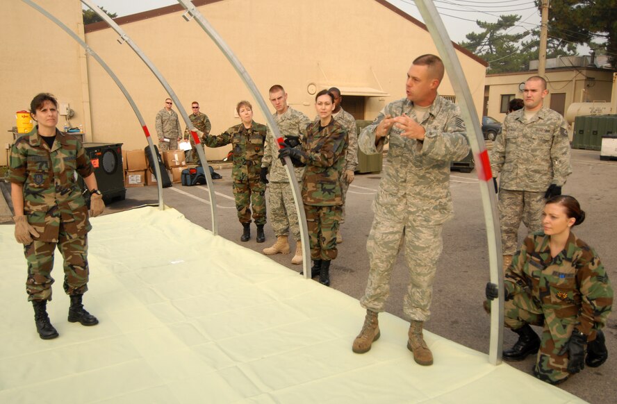 KUNSAN AIR BASE, Republic of Korea -- Tech. Sgt. Marc Paradis, 36th Medical Support Squadron from Anderson Air Base, Guam and also a native from San Antonio, TX, instructs airman from Luke Air Force Base, Ariz. and Westover Air Force Base, Mass. on constructing a madical staging facility here, Oct. 21. The Airman from Luke AFB and Westover AFB are reservist who are deployed here for training. (U.S. Air Force photo/Senior Airman Gustavo Gonzalez)