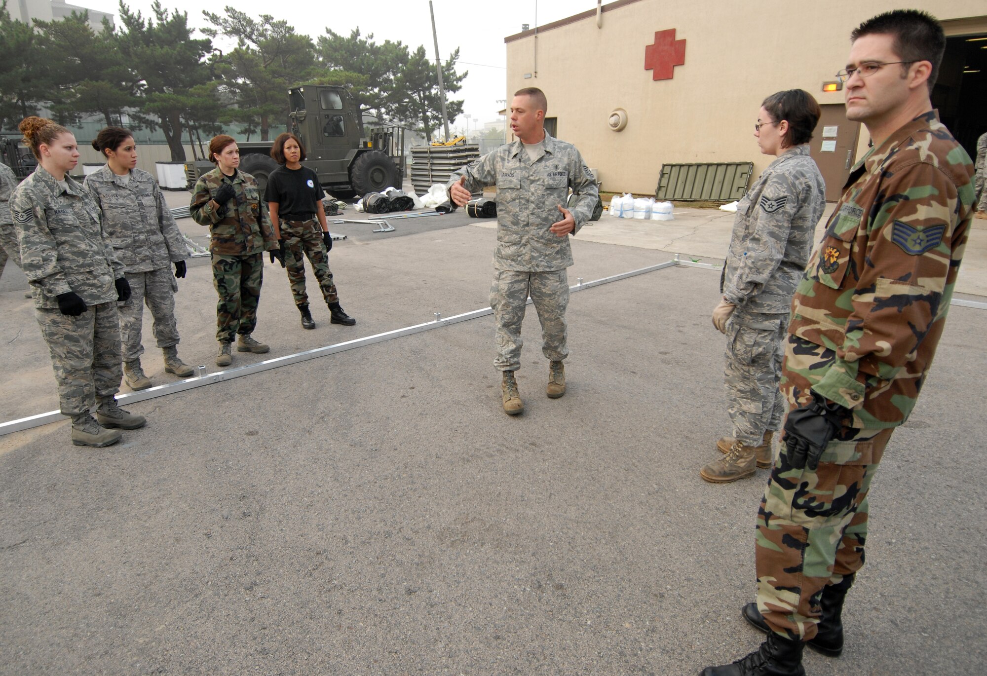 KUNSAN AIR BASE, Republic of Korea -- Tech. Sgt. Marc Paradis, 36th Medical Support Squadron from Anderson Air Base, Guam and also a native from San Antonio, TX, instructs airman from Luke Air Force Base, Ariz. and Westover Air Force Base, Mass. on constructing a madical staging facility here, Oct. 21. The Airman from Luke AFB and Westover AFB are reservist who are deployed here for training. (U.S. Air Force photo/Senior Airman Gustavo Gonzalez)