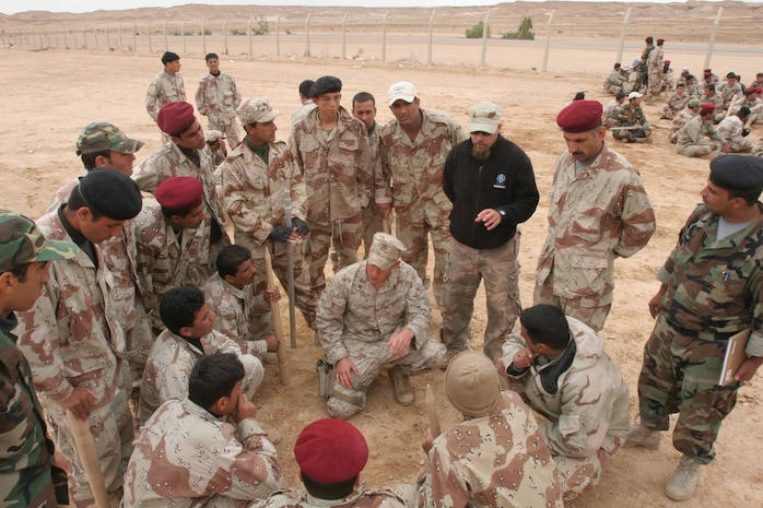 Cpl. Matthew Young (center), an infantryman with Grizzly Mobile, Regimental Combat Team 5, explains patrolling techniques to a group of Iraqi Army Soldiers at Al Asad, Iraq, Oct. 28.  The Iraqi soldiers took part in a 12-day advanced infantry training course and are vying to become part of an elite Iraqi special forces unit.::r::::n::