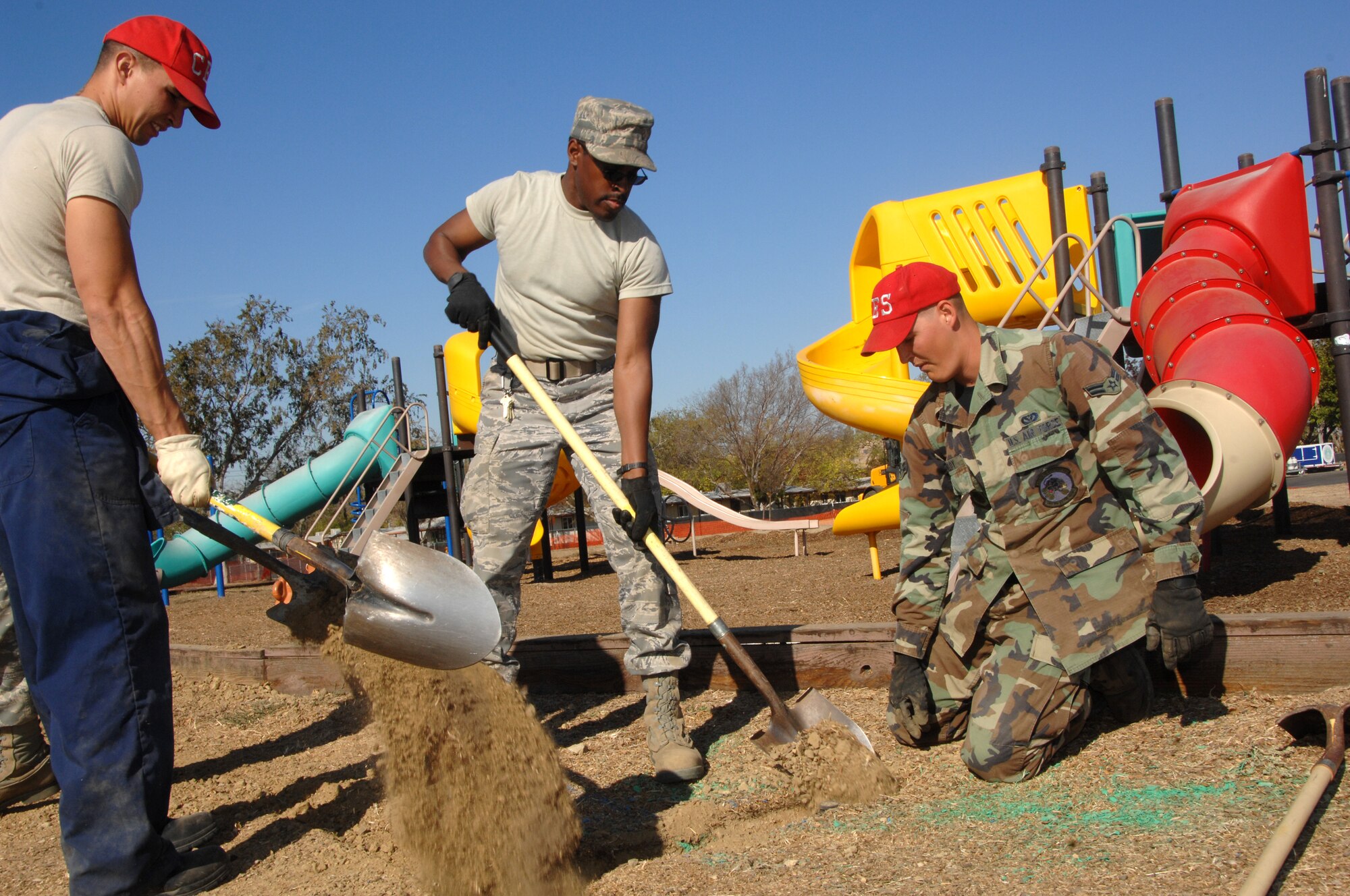 From left to right, Staff Sergeant Vong, Airman First Class Durante, and Airman First Class Weldy work together to fill in open trenches at Travisville park as part of a reconstruction project spearhead by the Civil Engineer Squardron. USAF photo by Civ/Amanda Lopez