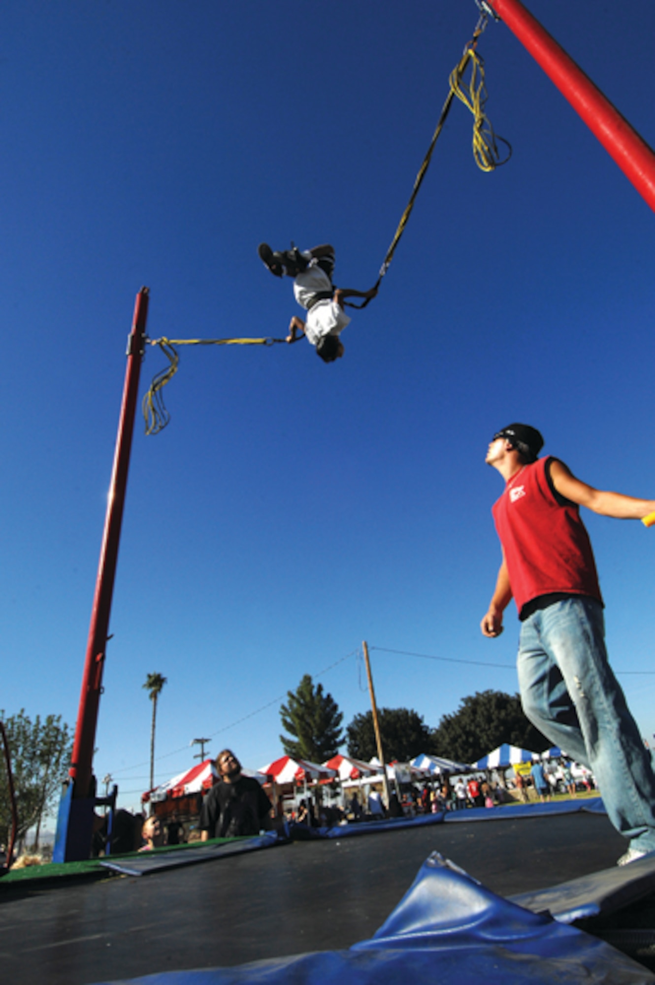 Rey Mendez, 9, does gravity defying flips on a giant trampoline. (U.S. Air Force photo/ Tech. Sgt. Jeffery Wolfe.)