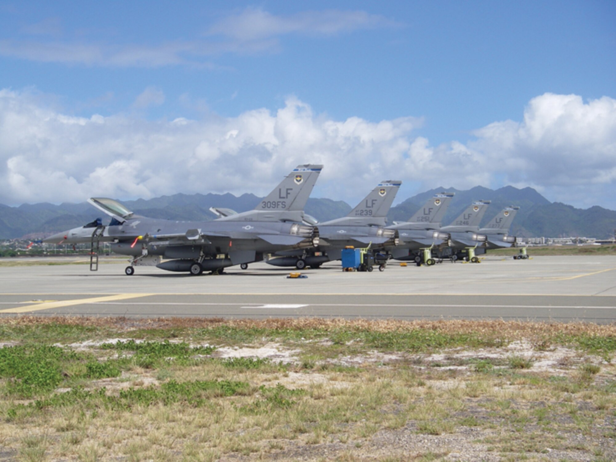 F-16s from the 309th Fighter Squadron sit on a parking ramp Oct. 23 at Hickam Air Force Base, Hawaii. The 309th FS deployed to Hickam to conduct dissimilar air combat training with the 199th FS. (U.S. Air Force photo/ Tech. Sgt. Niclas Svensson.)