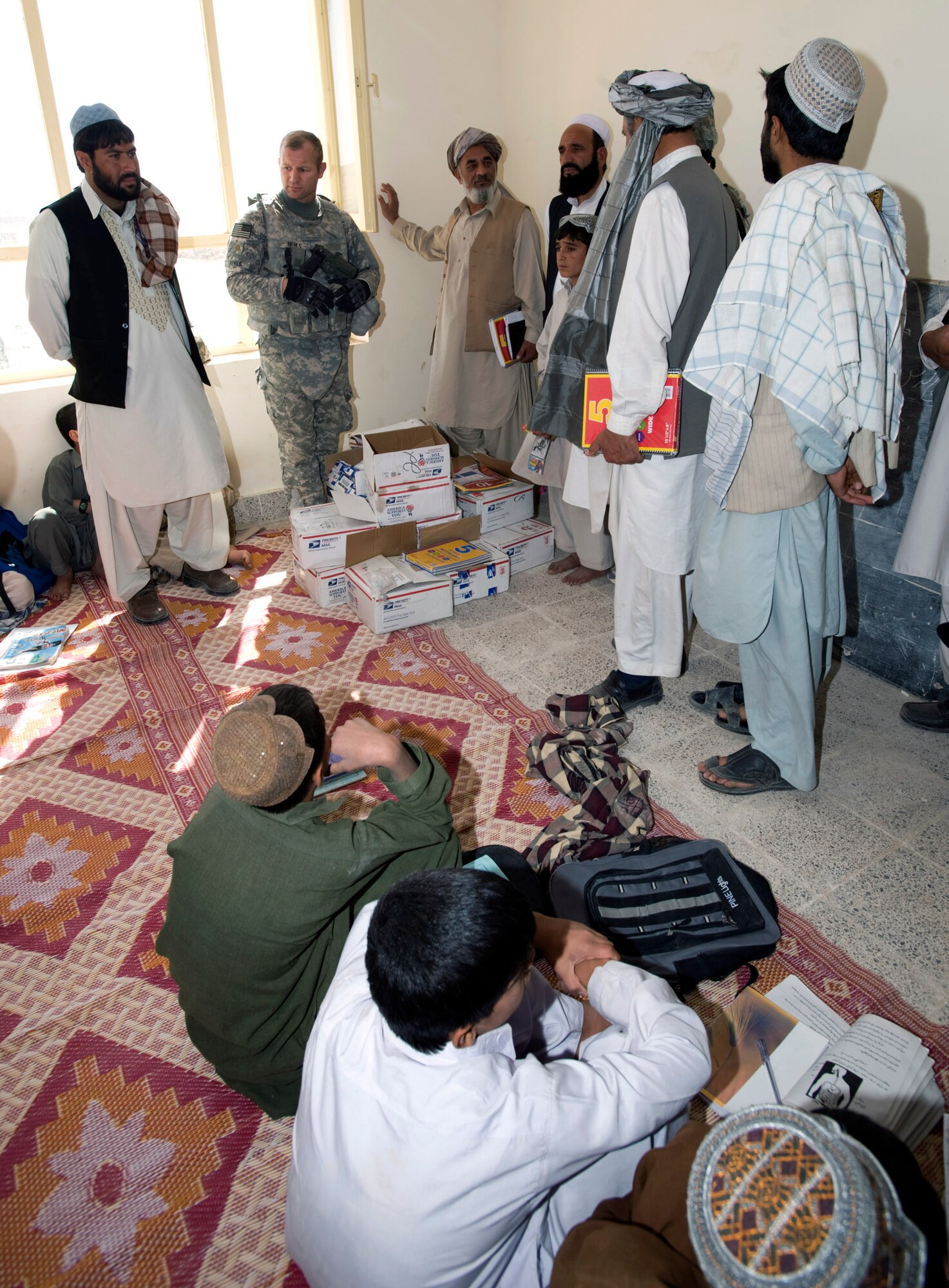 Army Maj. Trever Nehls and school leaders talk with students about the supplies being donated to them. The Zabul Provincial Reconstruction Team delivered a truck full of school supplies donated from the Westfield Community School in Algonquin, Ill. Major Nehls, PRT civil affairs leader, is deployed from the 451st Civil Affairs Battalion, Pasadena, Texas. (U.S. Air Force photo/Master Sgt. Keith Brown) 
