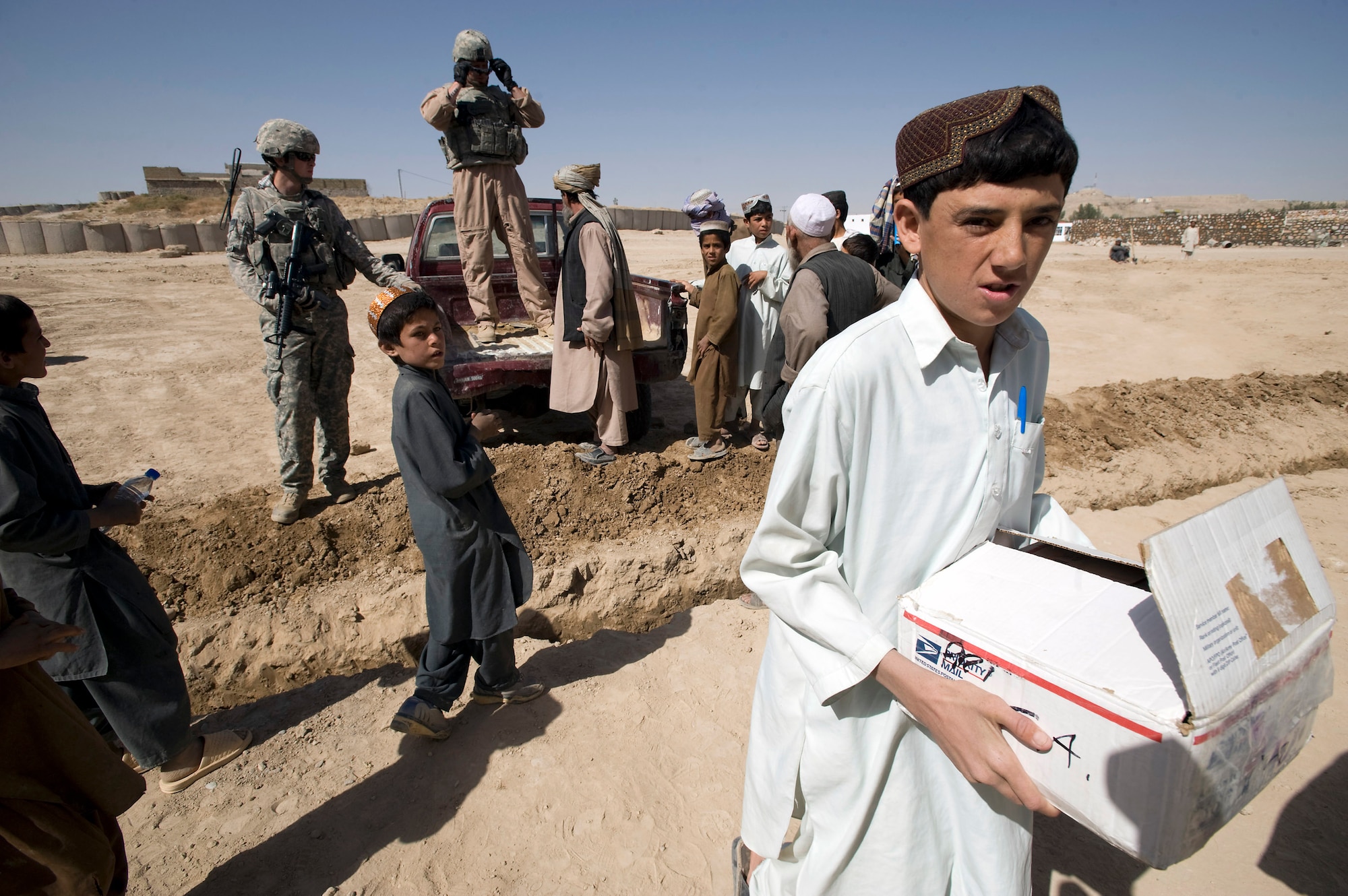 An Afghan child carries a box of school supplies delivered to his school by the Zabul Provincial Reconstruction Team on behalf of the Westfield Community School in Algonquin, Ill. The donated school supplies ranged from pens and crayons to notebooks and glue. (U.S. Air Force photo/Master Sgt. Keith Brown) 
