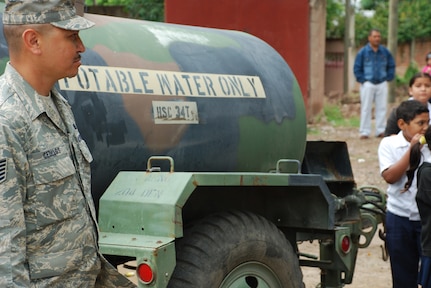 SOTO CANO AIR BASE, Honduras - Air Force Tech. Sgt. Ramano Cedillos, deployed from the Phoenix Air National Guard, assists people in getting clean water Oct. 29. After the water is filtered, it is placed in 500-gallon water buffalos so people have free access to the purified water. (U.S. Army photo by Specialist Ethan Anderson)