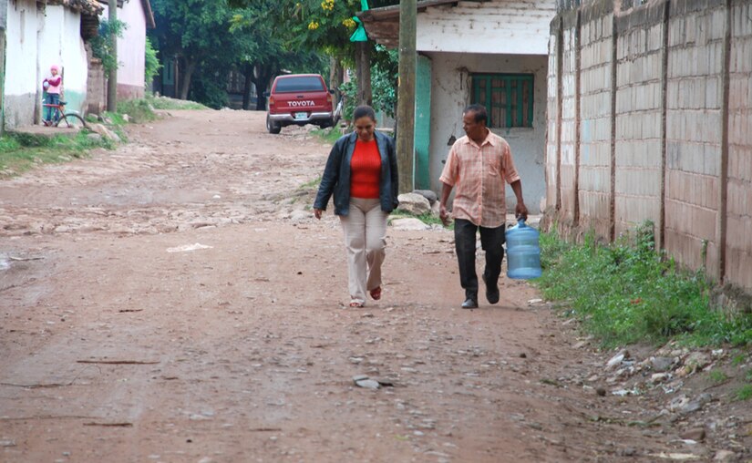 SOTO CANO AIR BASE, Honduras - A family walks down the road to get the free purified water provided by Joint Task Force-Bravo Oct. 29. Before JTF-Bravo offered to purify the well water affected by the flooding, the community had to have water trucked in at great expense to them. (U.S. Air Force photo by Staff Sgt. Joel Mease)