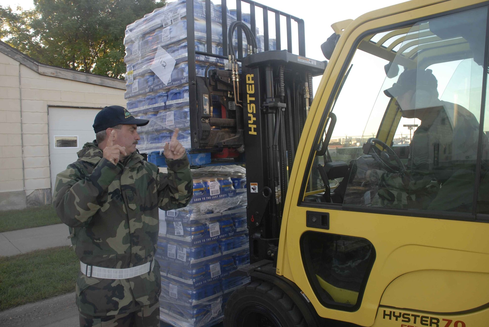 Tech. Sgt. Robert Losey, 27th Aerial Port Squadron, directs Staff Sgt. Caleb Nelson, 27 APS as he moves cases of coffee in preparation for the Commissary case lot sale Oct. 3-4. The sale offered commissary eligible shoppers the opportunity to purchase case lots of food and supplies at Air Force Commissary prices. (Air Force photo/Master Sgt. Paul Zadach) 